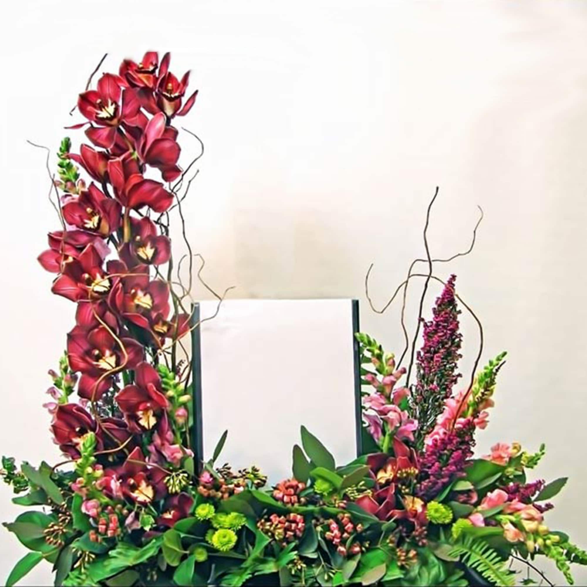 Tall red orchid and pink flower arrangement framing a central photo holder