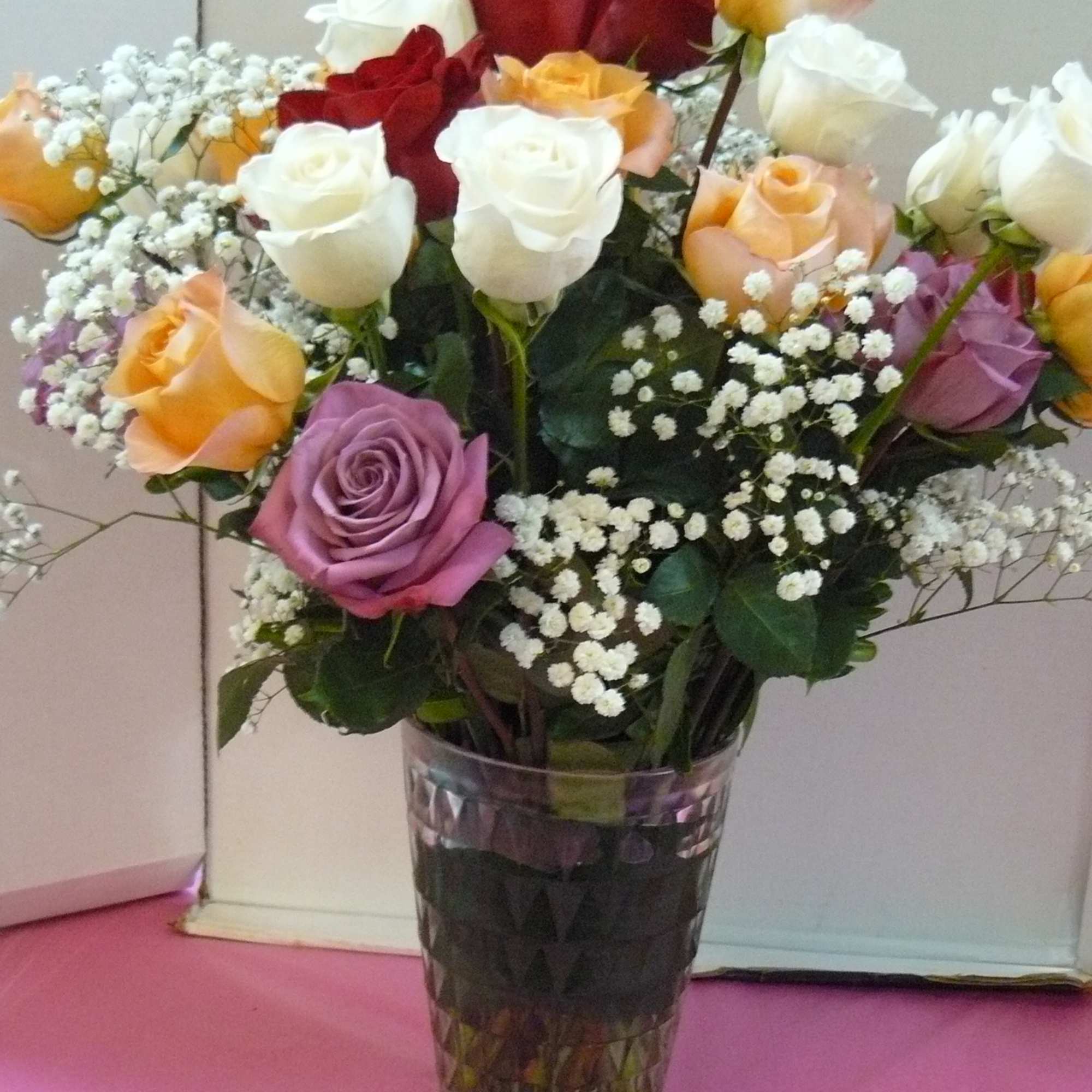 Mixed roses in a clear glass vase with baby's breath, photo 2 of 3