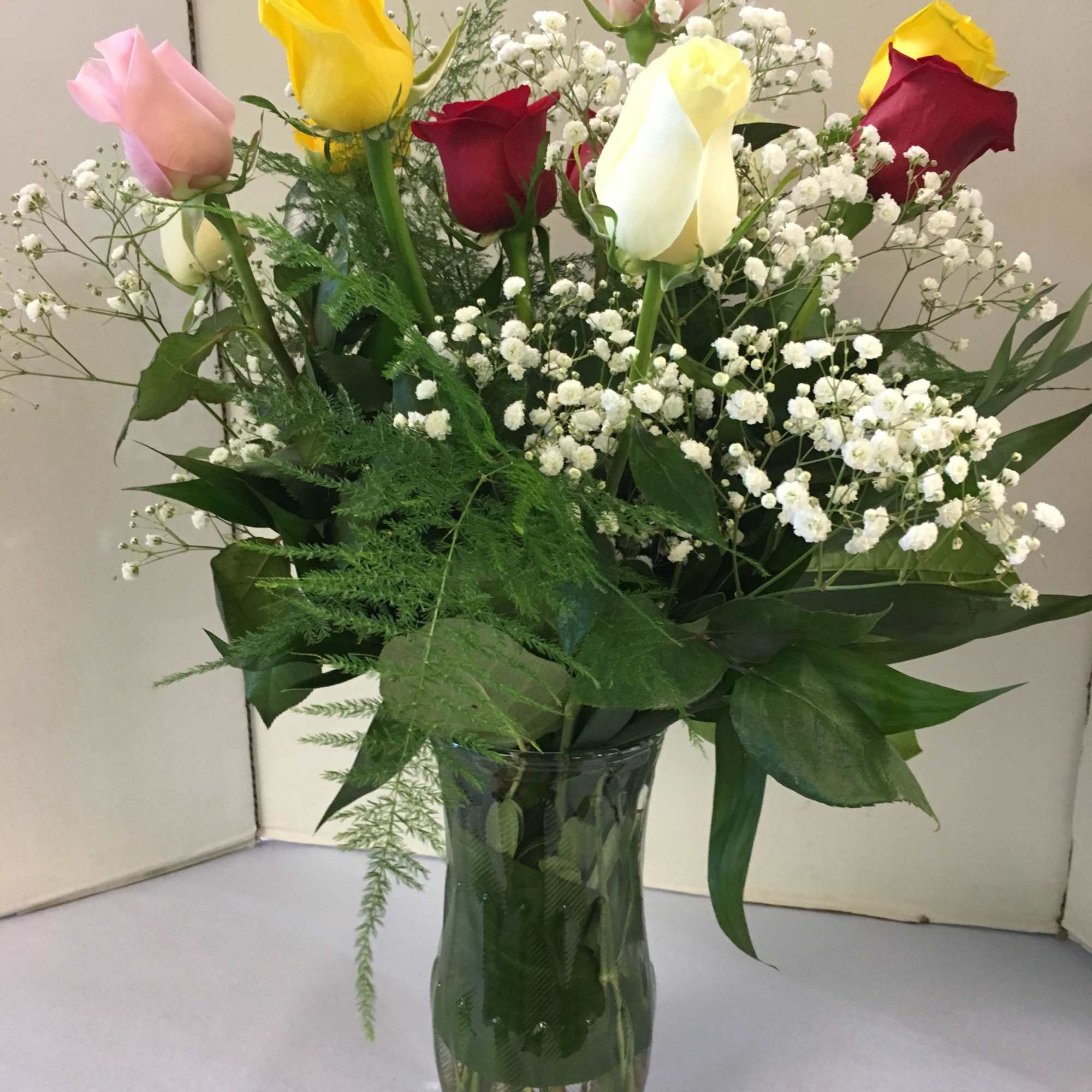 Mixed roses and baby's breath in a glass vase