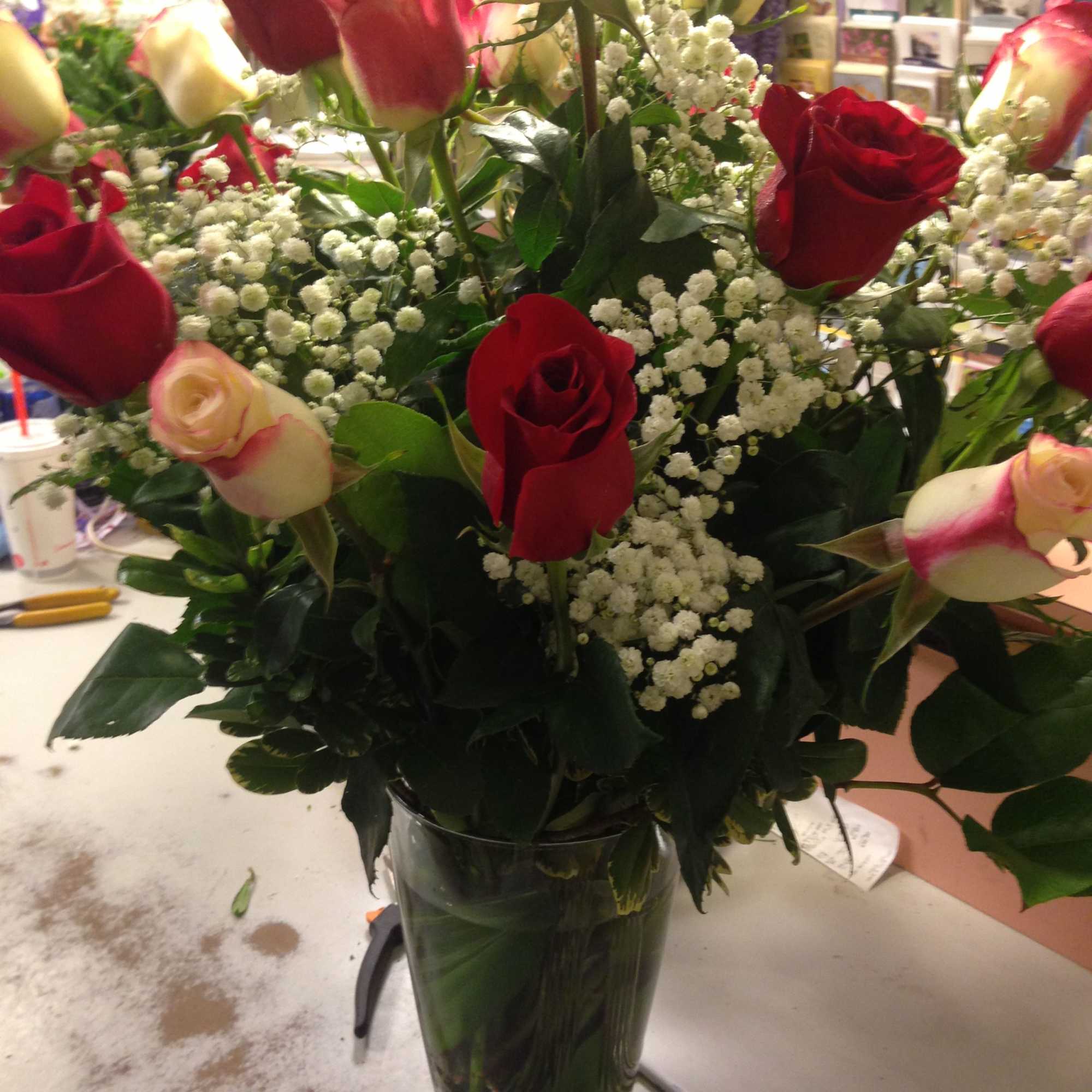 Bouquet of red and cream roses in a glass vase