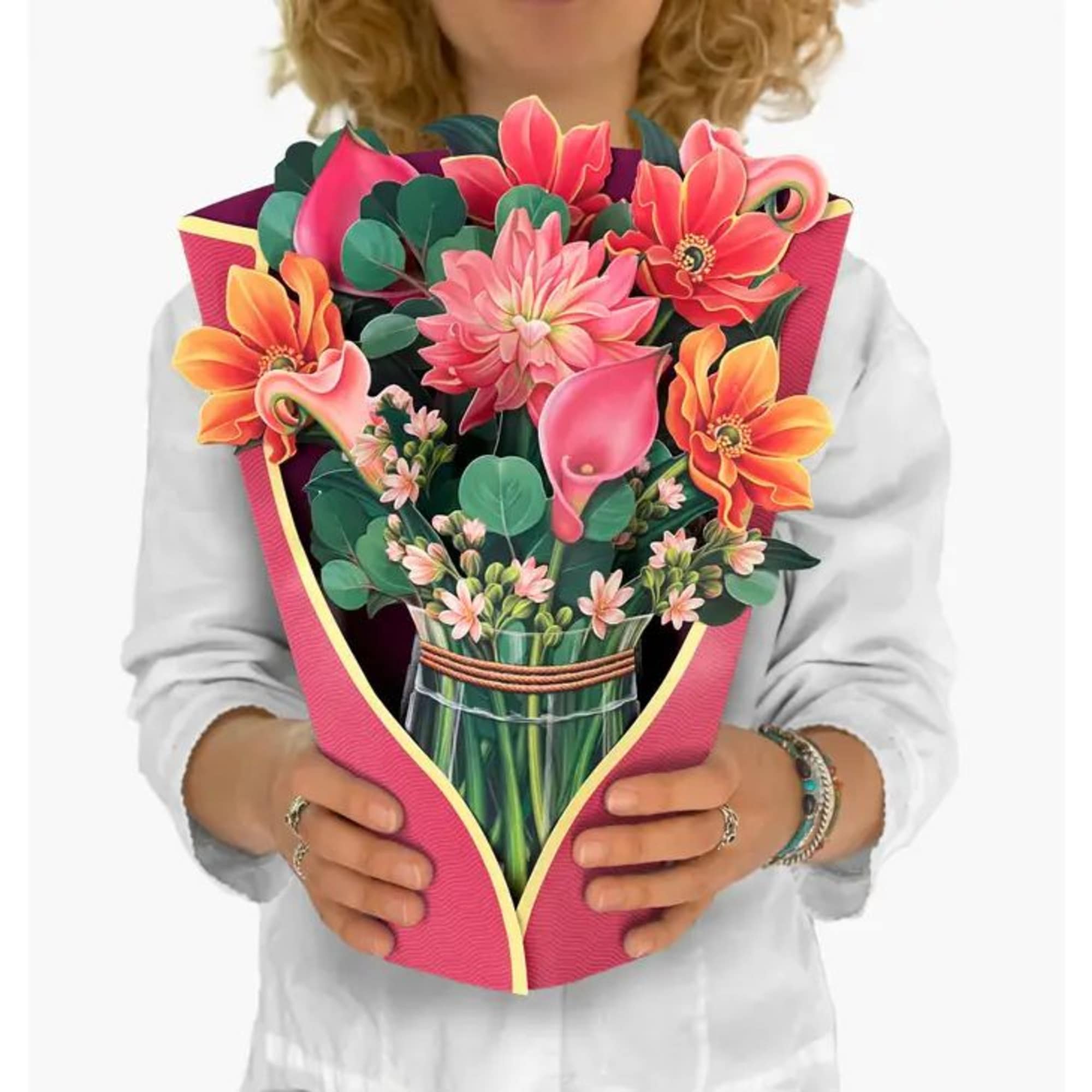 Person holding a large flat pop-up bouquet card with bright pink and orange flowers in a faux vase.