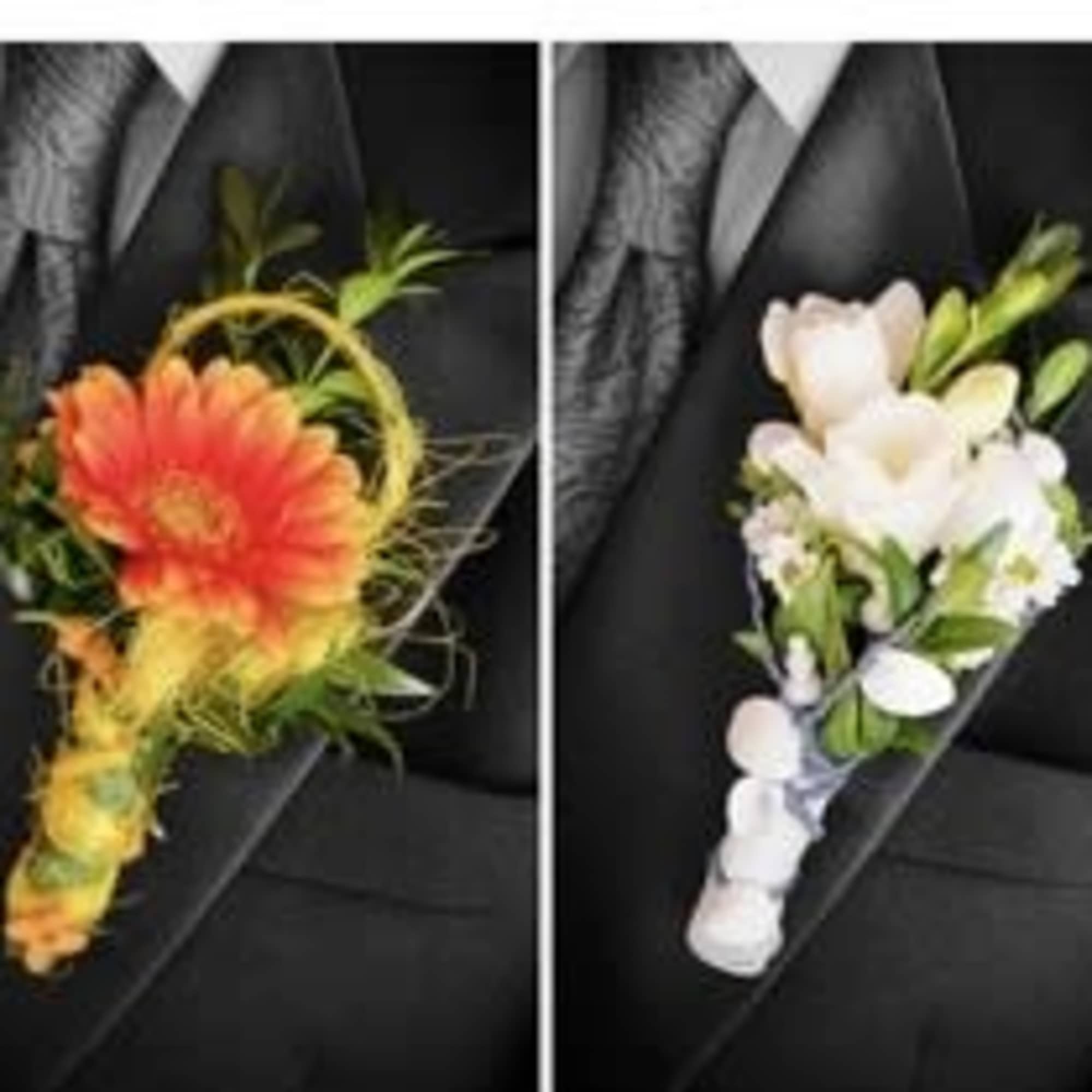 Four floral boutonnieres on black fabric, each with a single bloom and ribbon-wrapped stem.