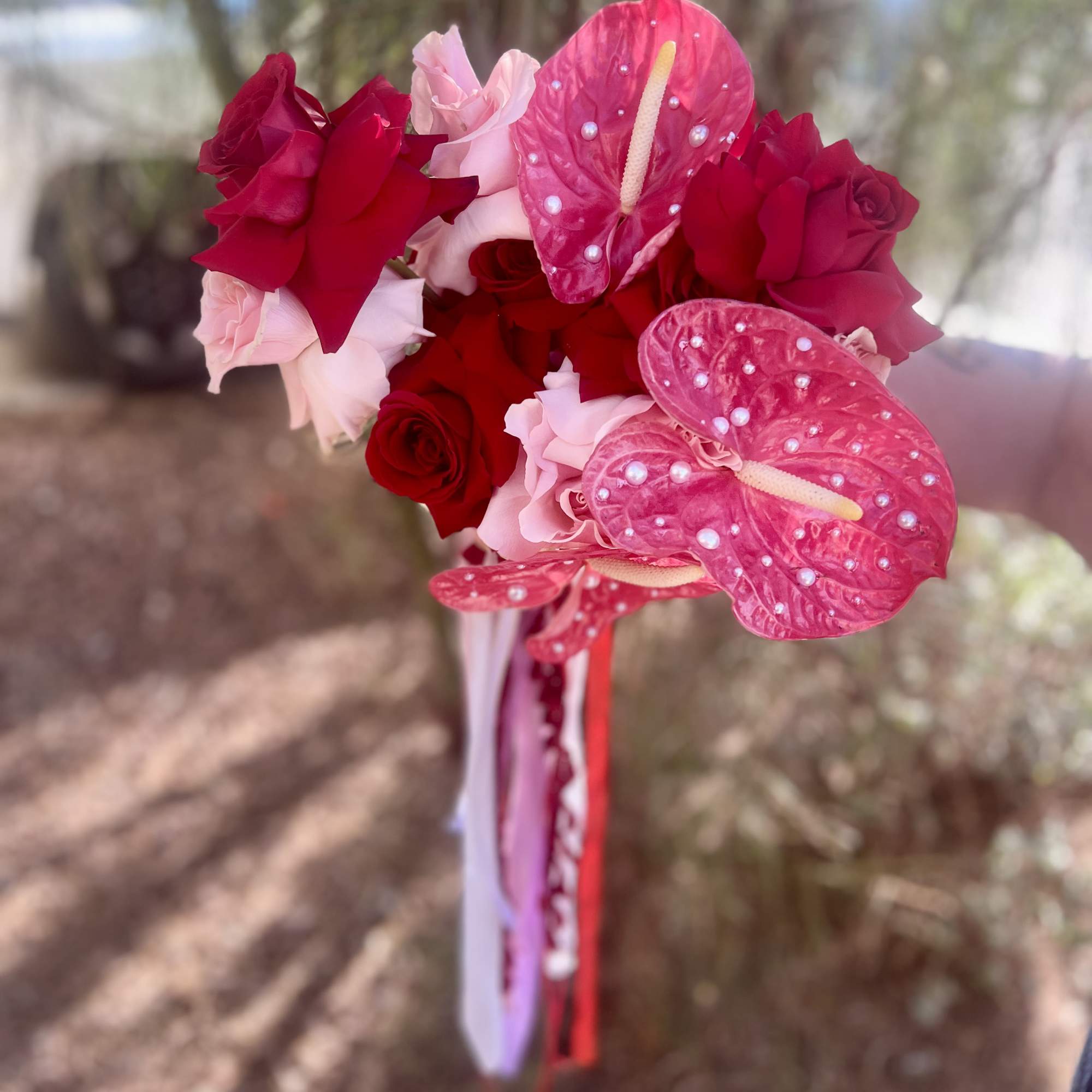 Bouquet of red and pink roses with bright pink anthuriums