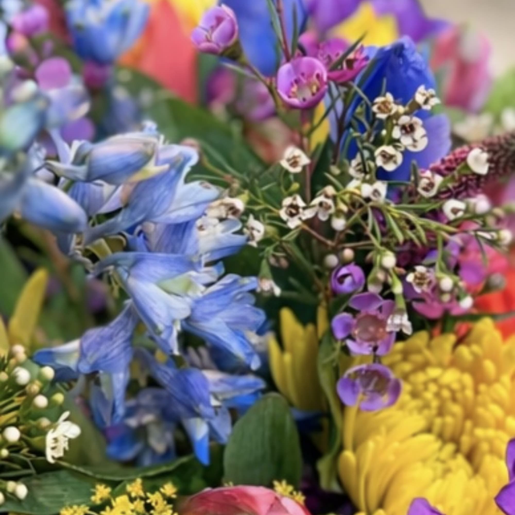 Colorful mixed bouquet with blue, purple, yellow, and pink flowers