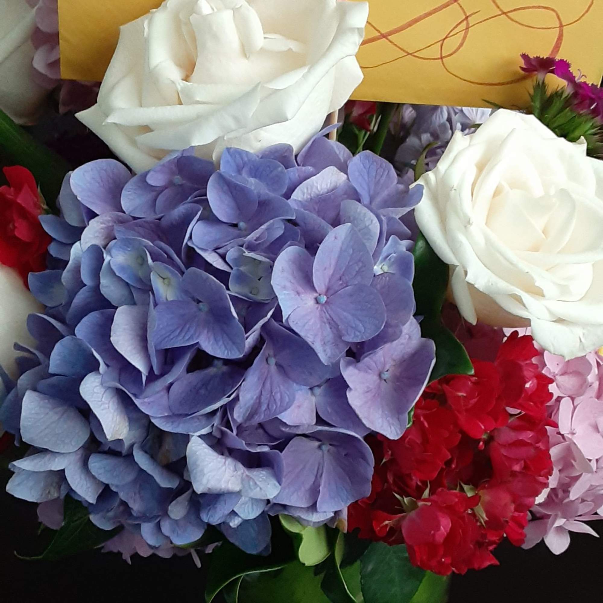 Bouquet of white roses and purple hydrangeas with a yellow card