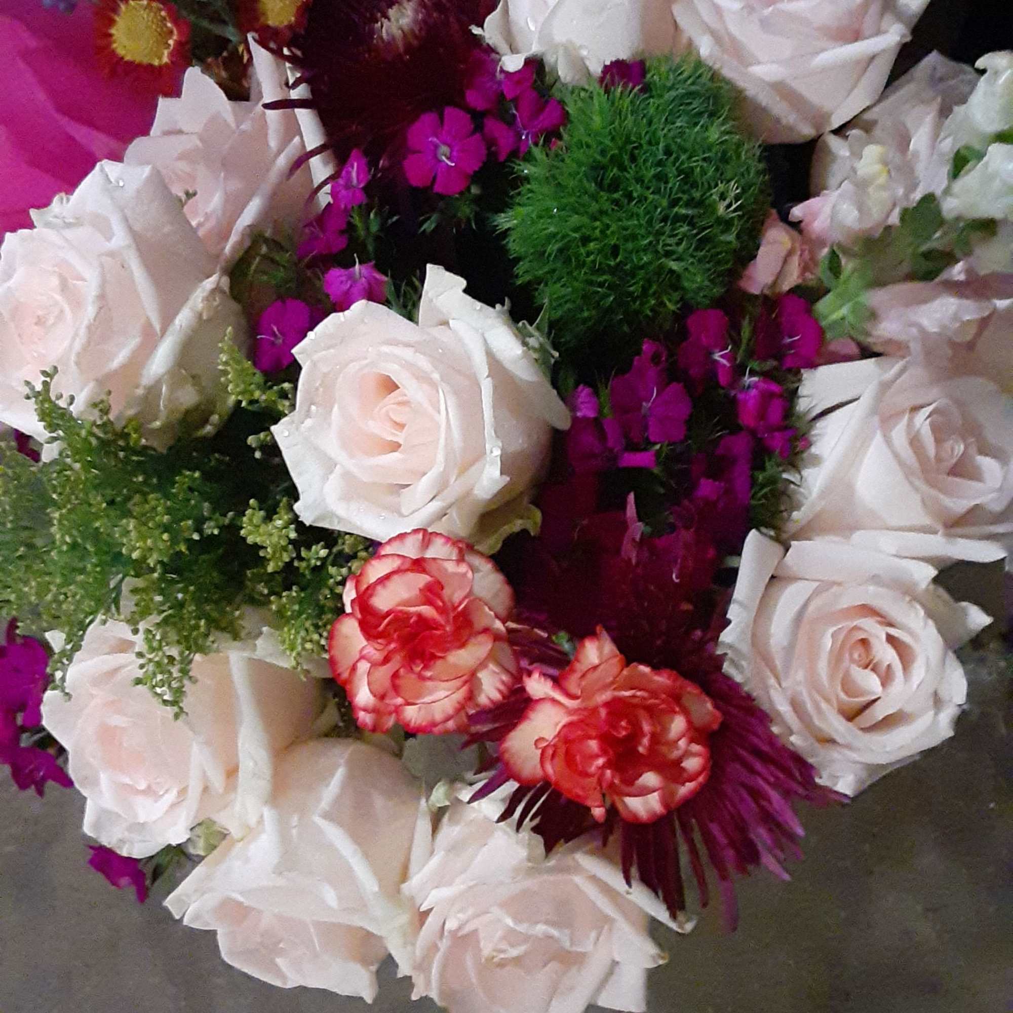 Bouquet of pale pink roses with magenta accent flowers