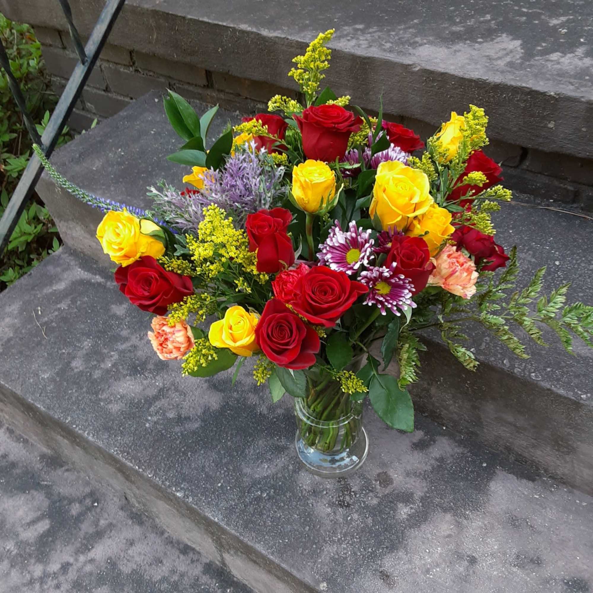 Bouquet of red and yellow roses in a clear glass vase