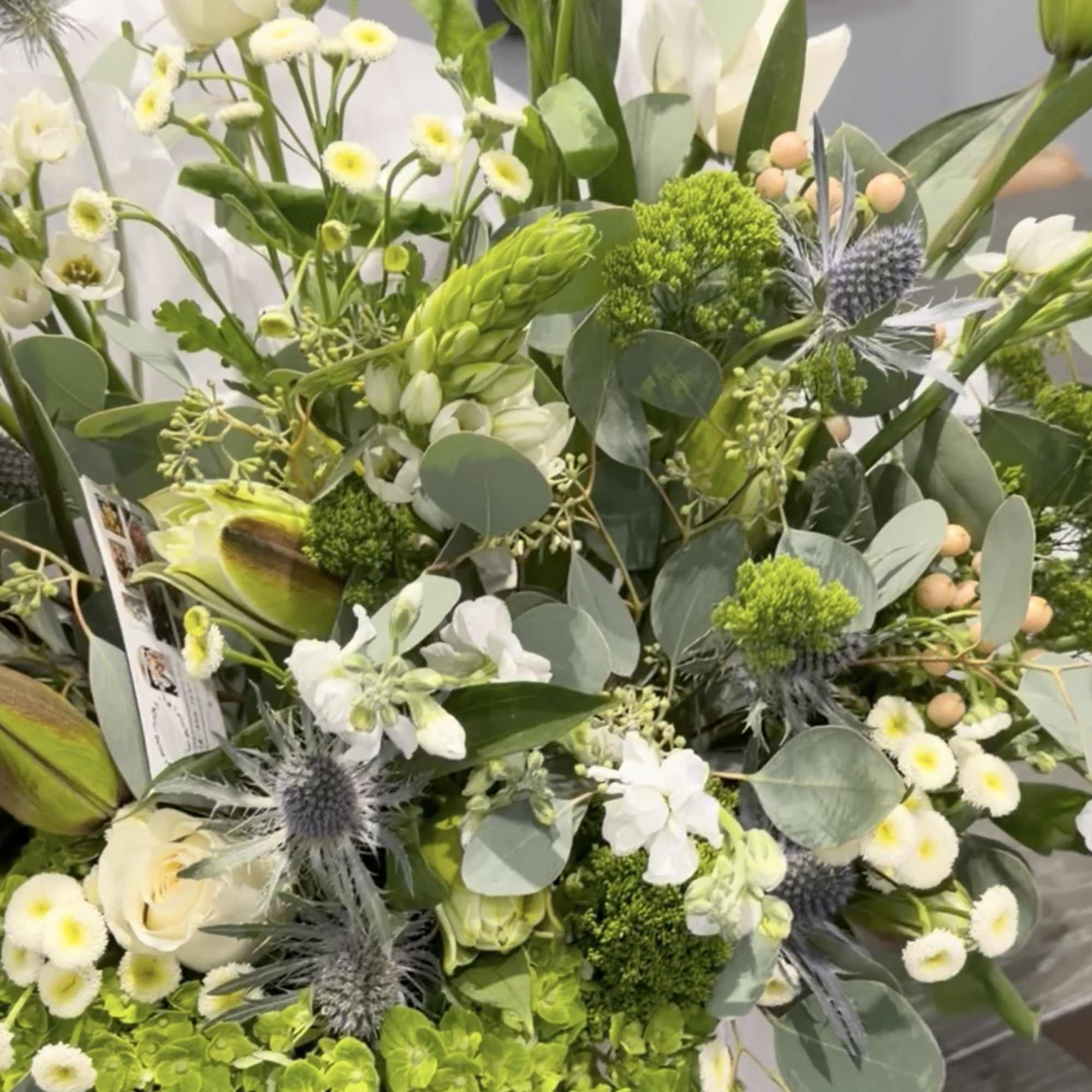White and green mixed bouquet in a white hatbox