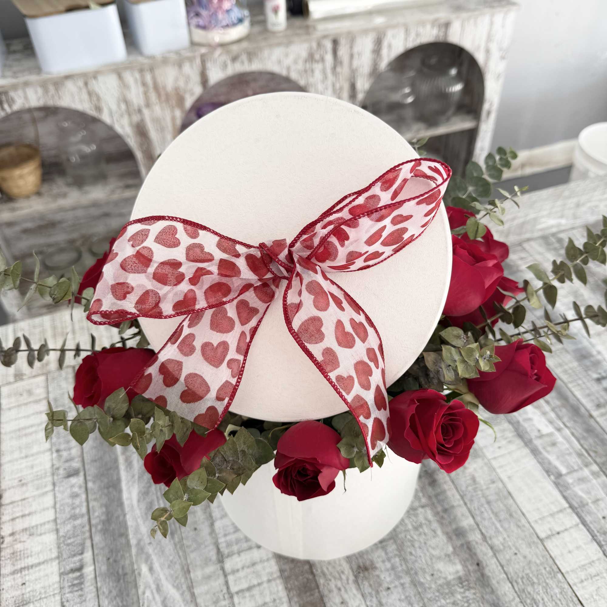 White hat box with red roses and a heart-pattern ribbon