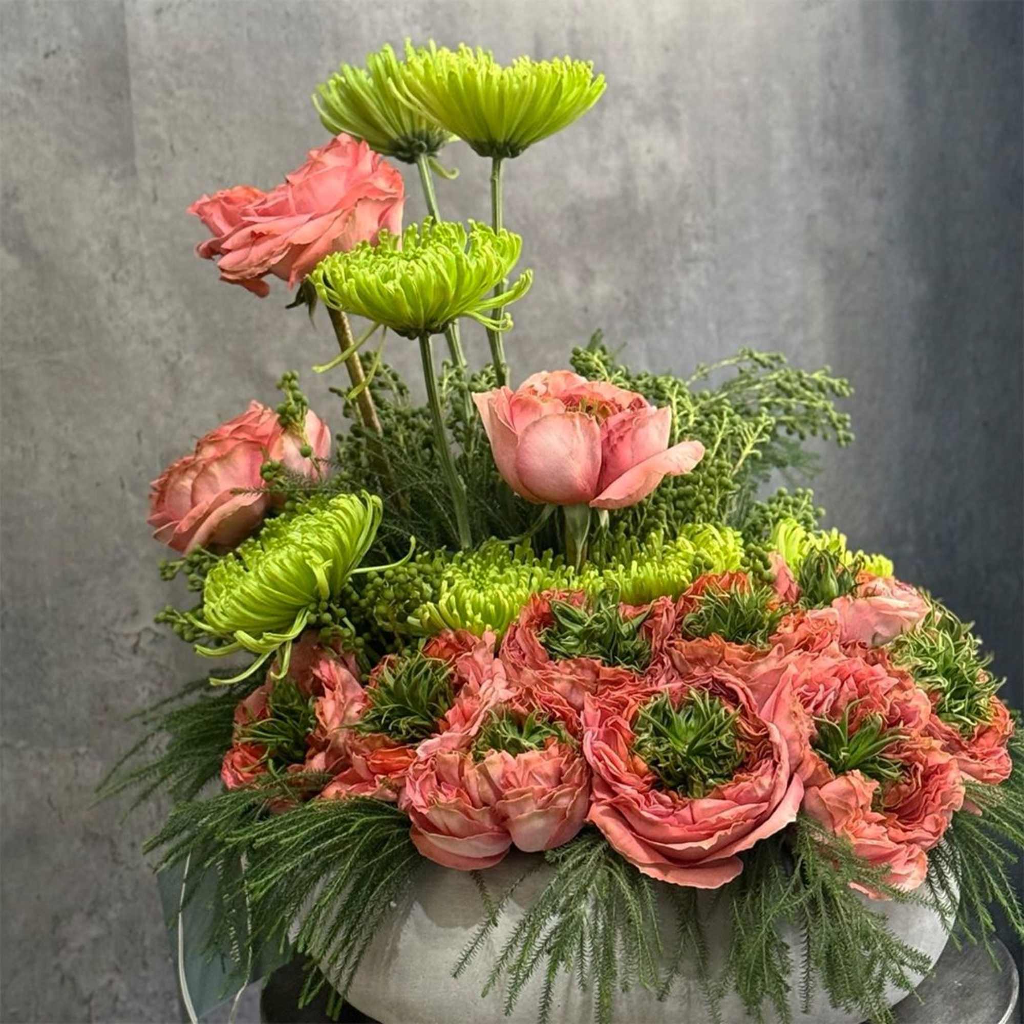 Pink roses and green chrysanthemums in a low white container