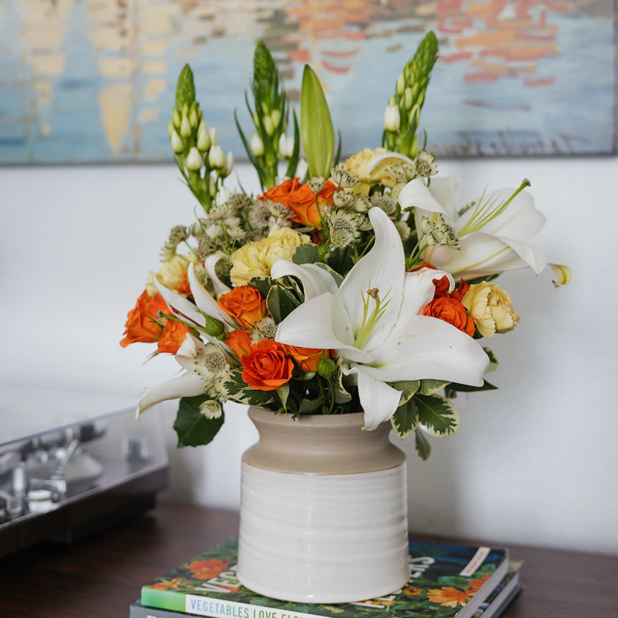 Orange roses and white lilies arranged in a ceramic vase, photo 2 of 3