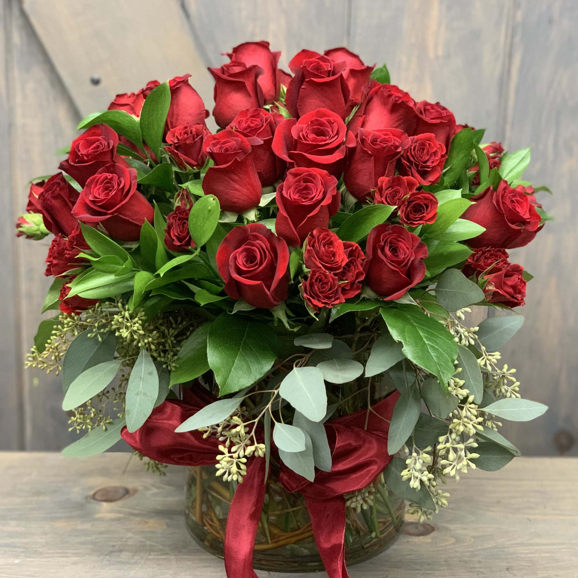 Bouquet of red roses in a glass vase with red ribbon