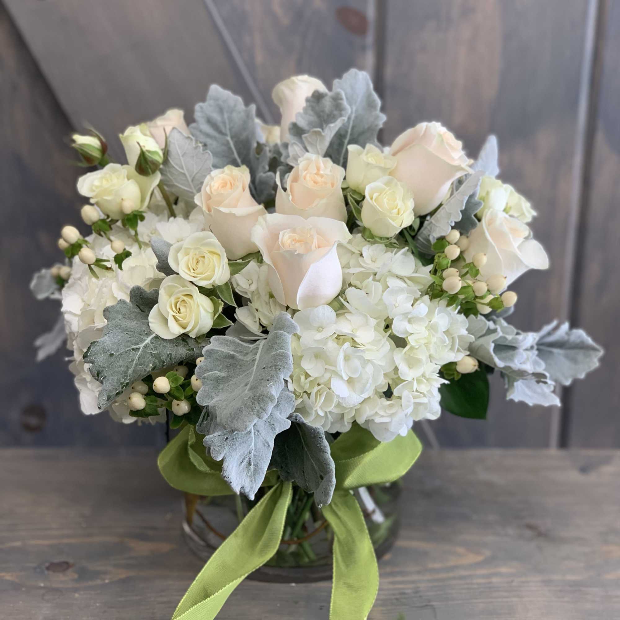 White and blush rose bouquet with hydrangeas in a glass vase