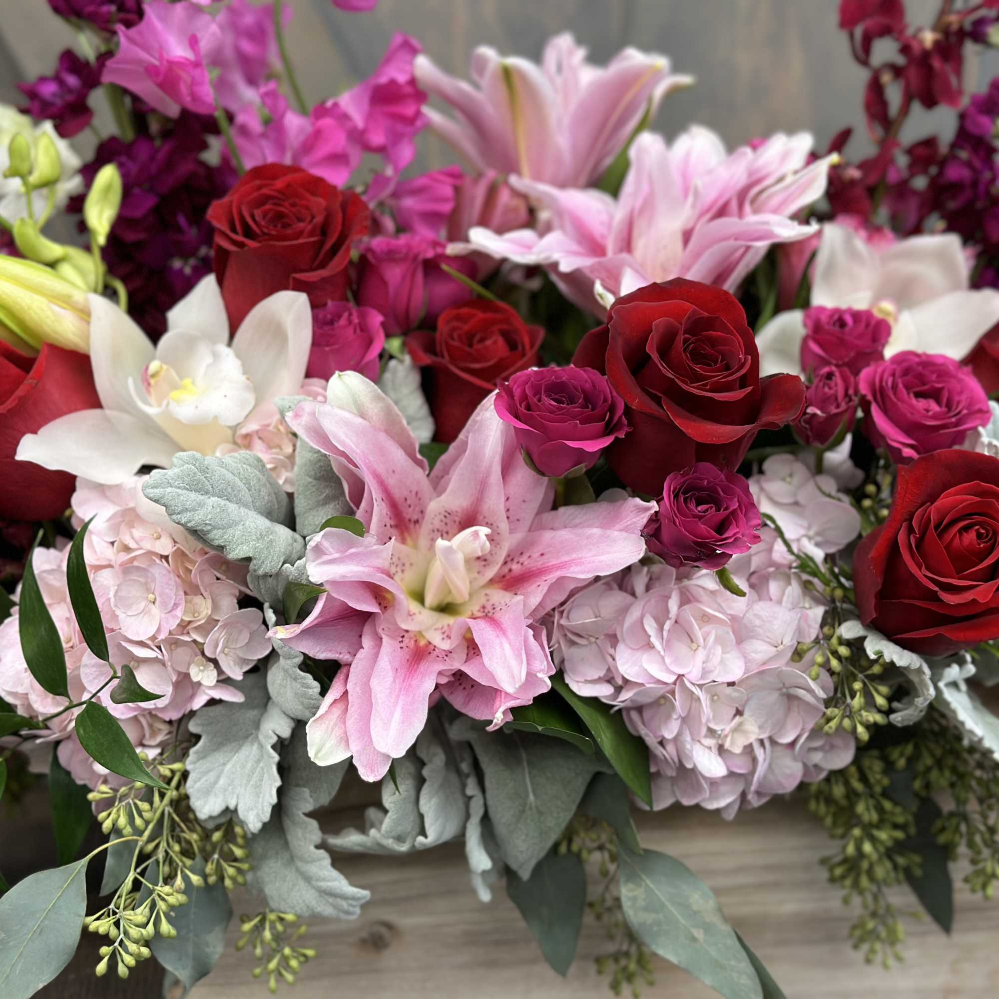 Mixed bouquet of red roses, pink lilies, and pale hydrangeas