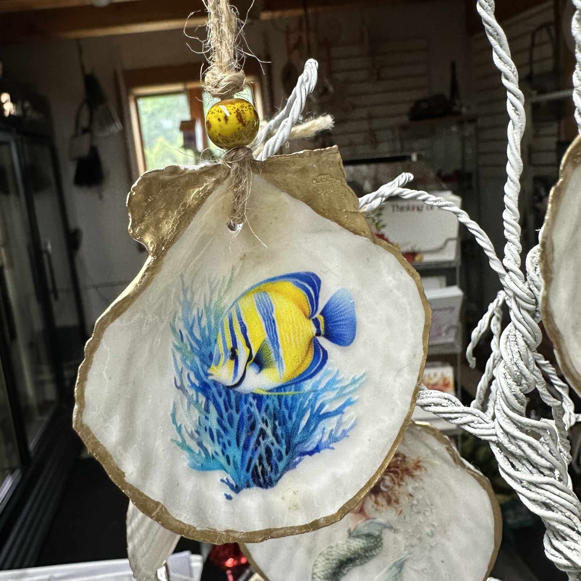 Hanging shell ornament with a painted tropical fish design