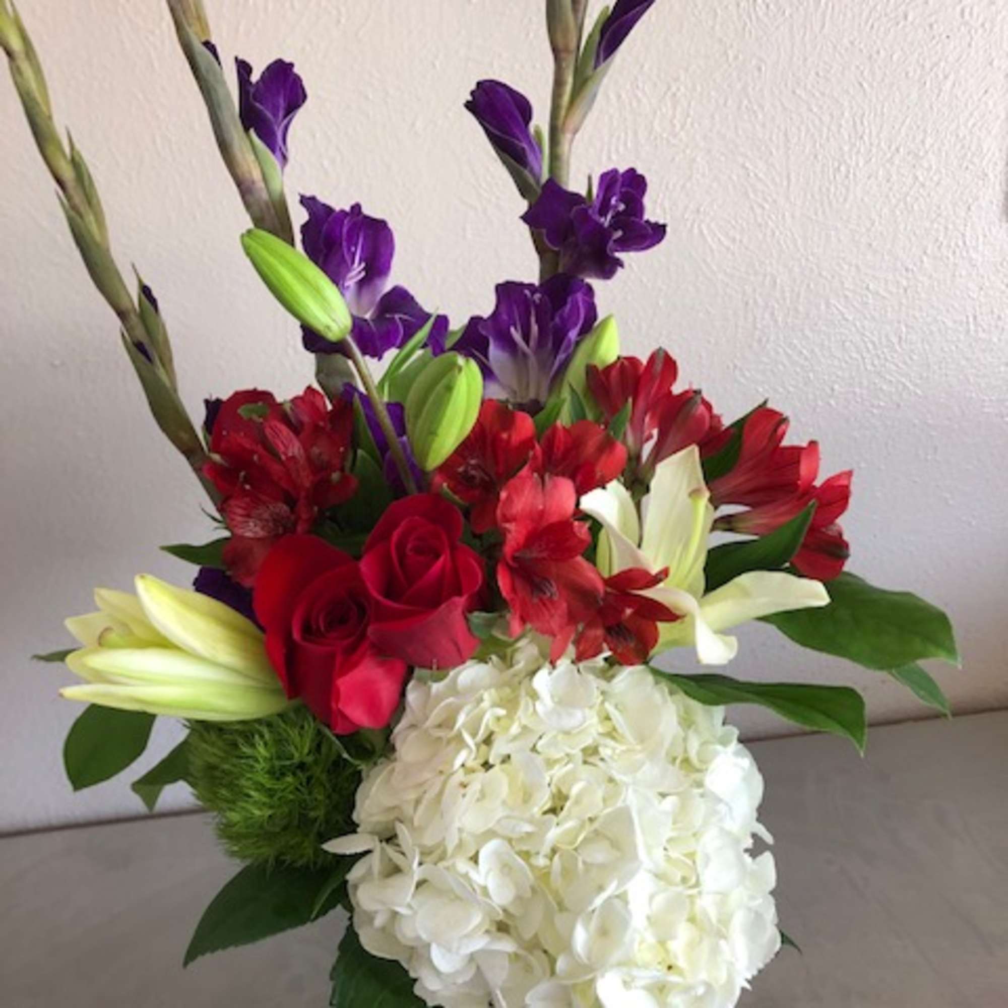 Bouquet with red roses, white hydrangea, purple flowers, and lilies