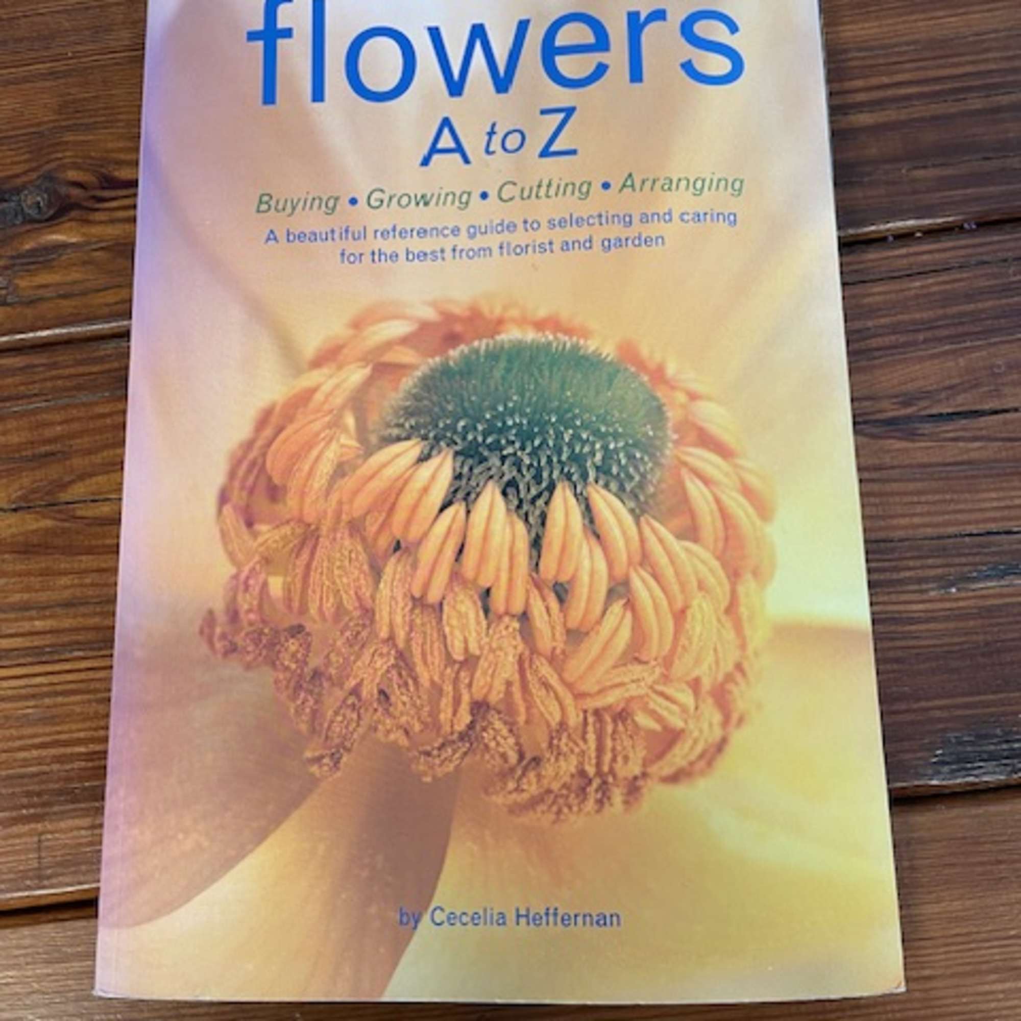 A book titled "flowers A to Z" on a wooden surface