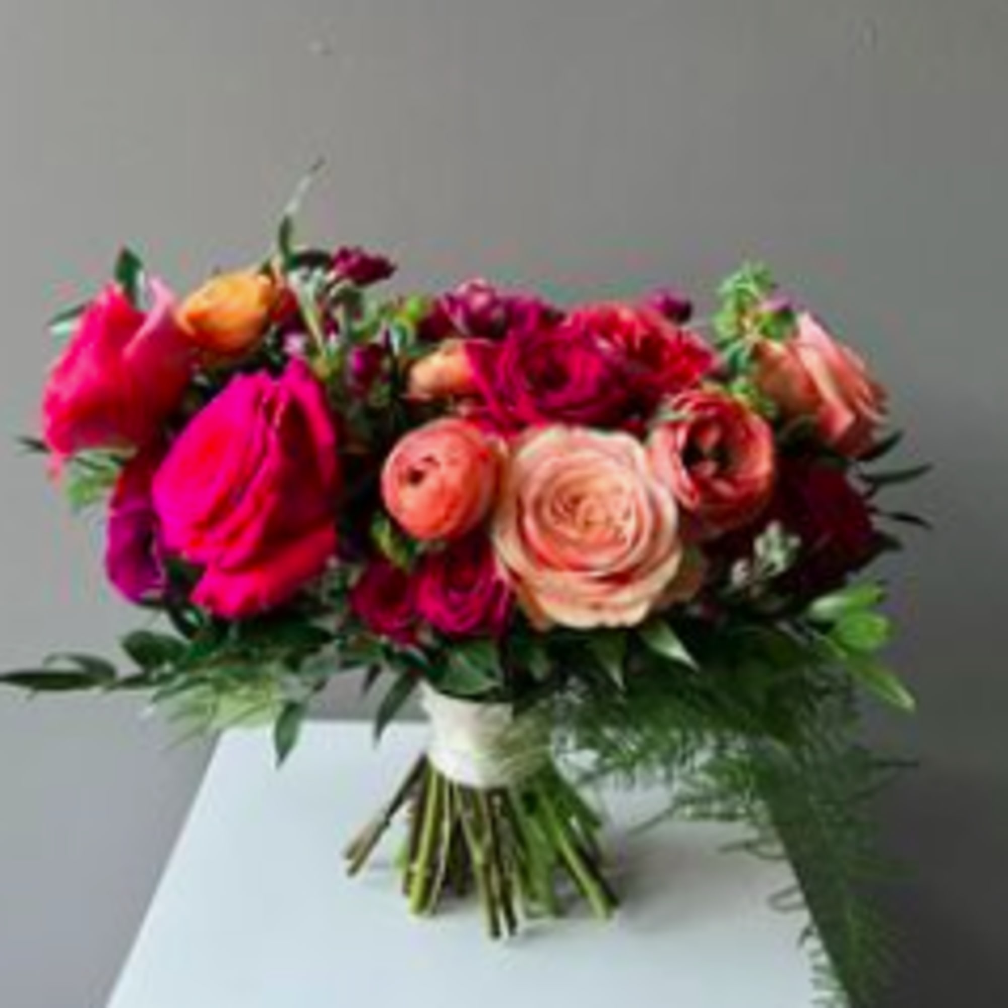 Bouquet of pink and peach roses with greenery