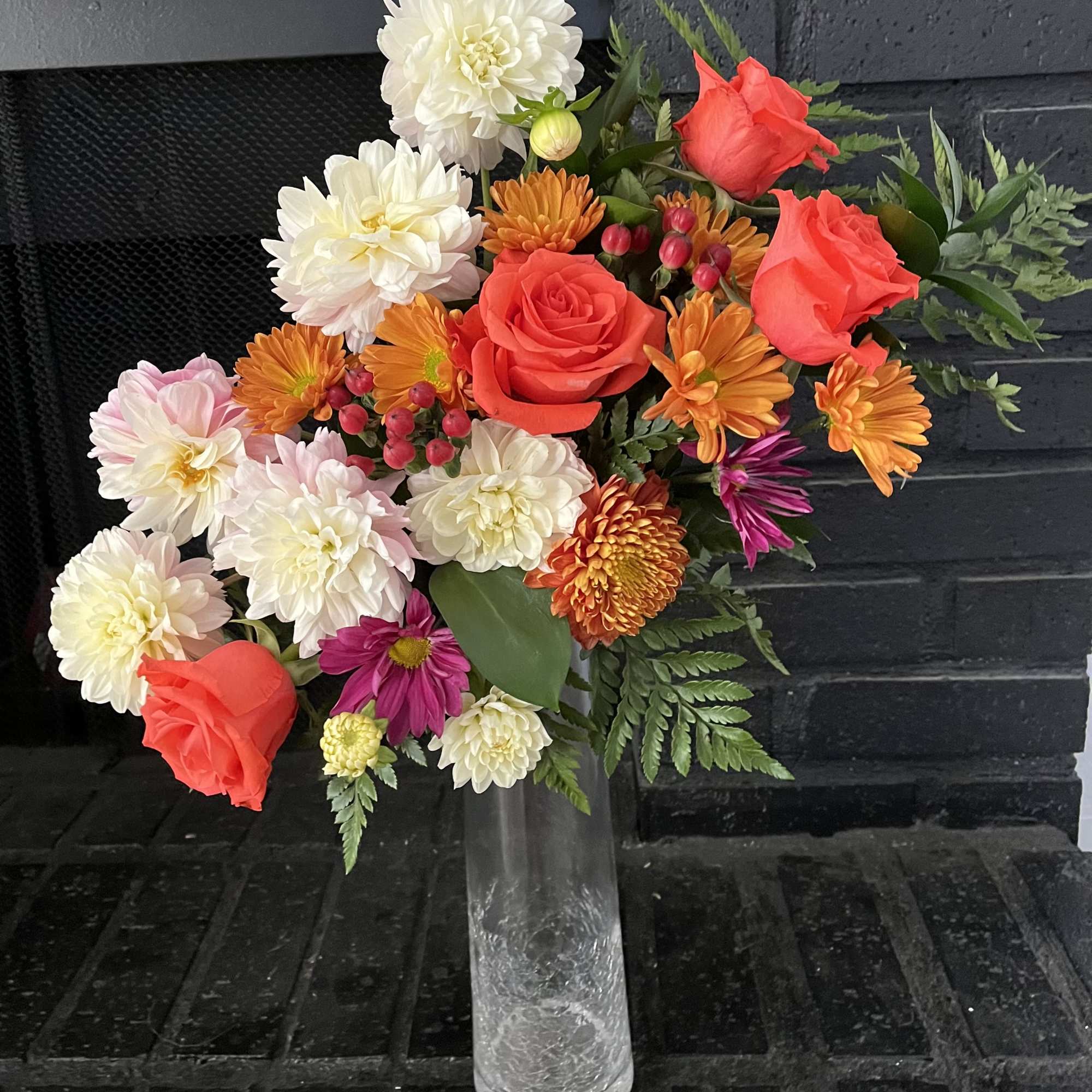 Mixed bouquet of roses and chrysanthemums in a clear glass vase
