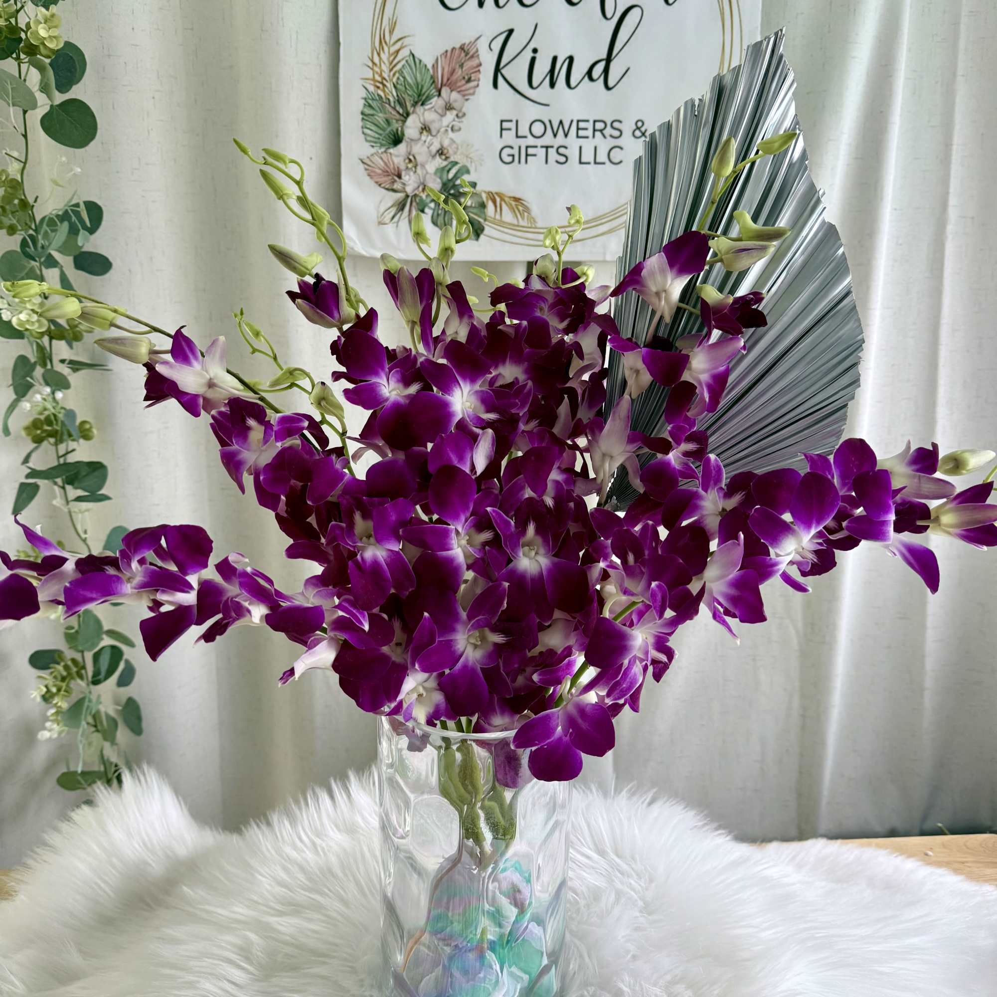 A dreamy arrangement of lush purple orchids with soft white accents, designed