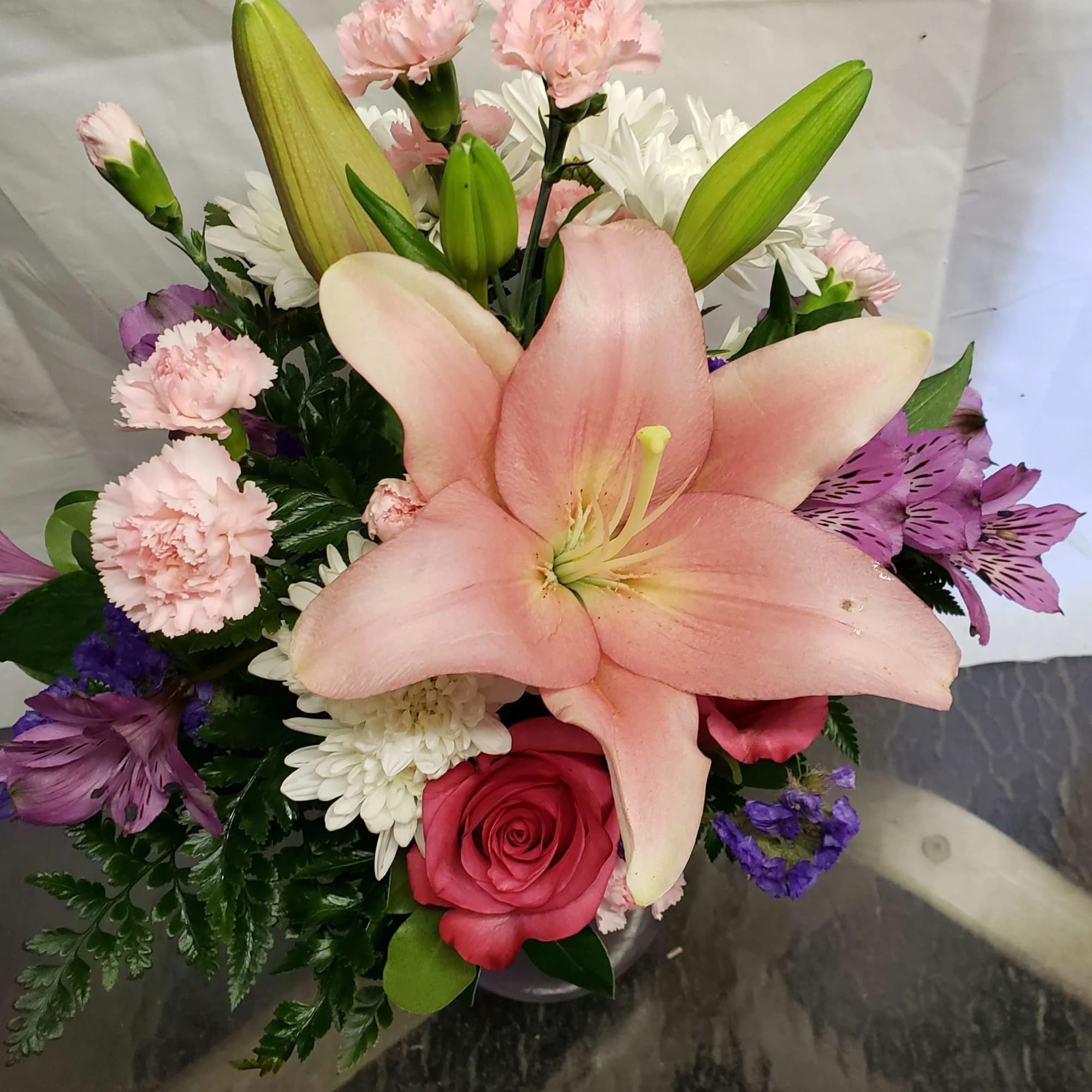 Pink lily bouquet with roses, carnations, and white daisies