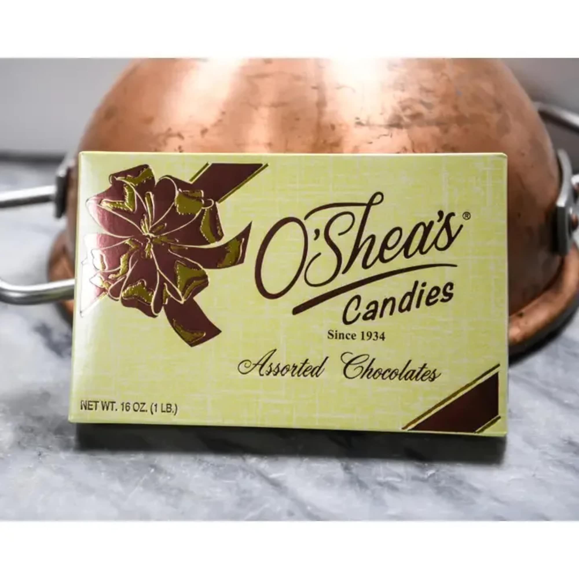 Box of assorted chocolates in front of a copper pot