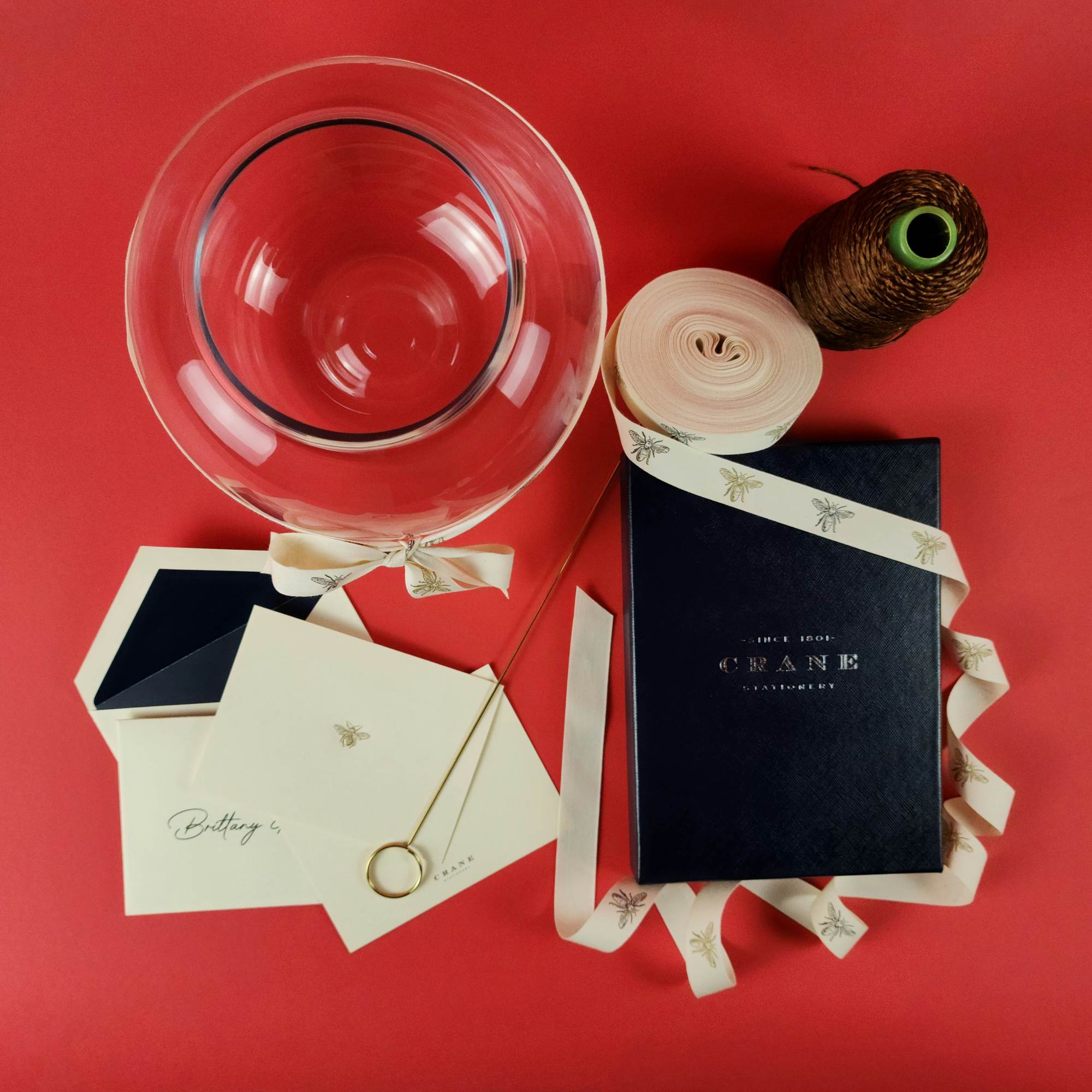 Clear balloon, ribbon, cards, and a gift box on a red background