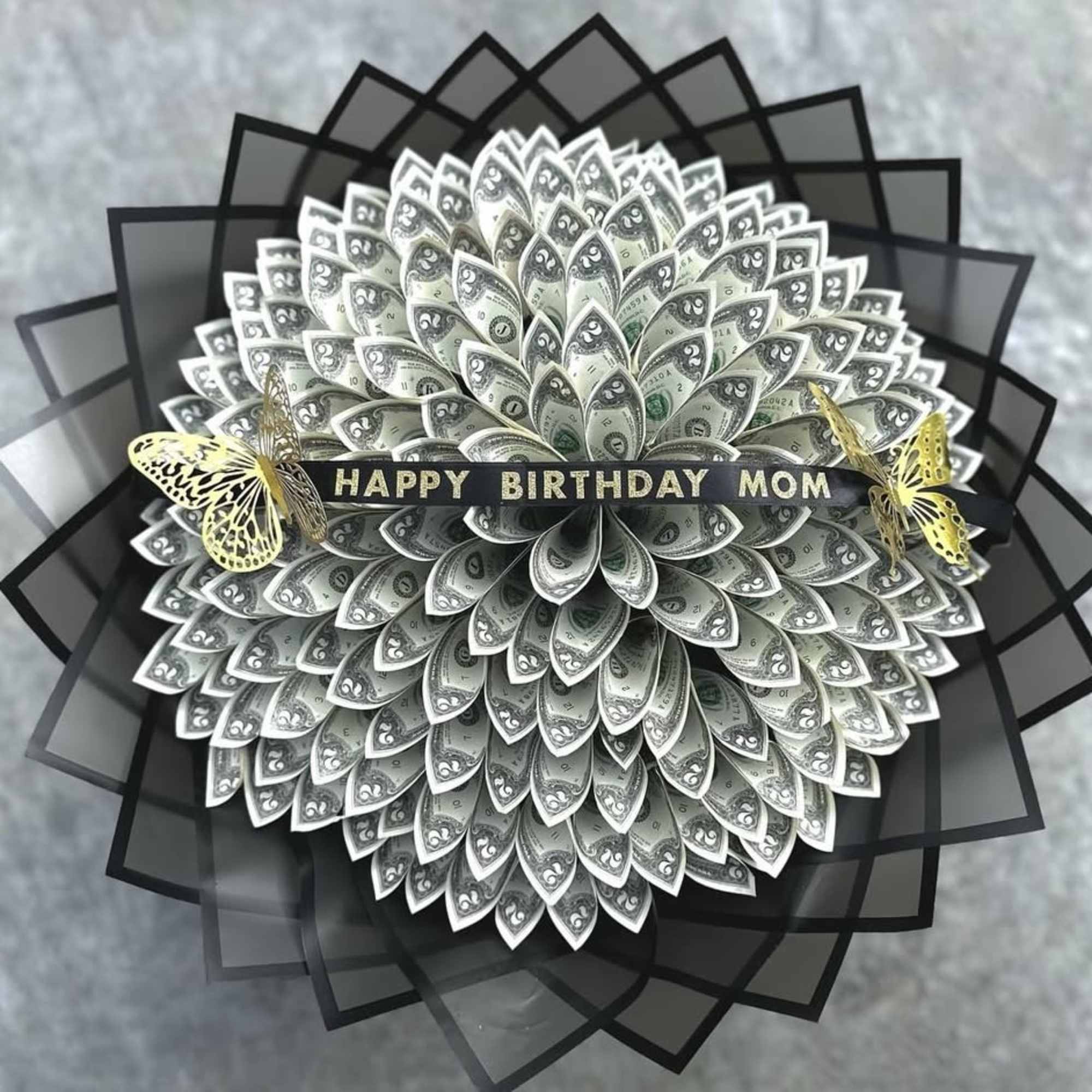 Money bouquet with a "Happy Birthday Mom" ribbon and butterfly accents