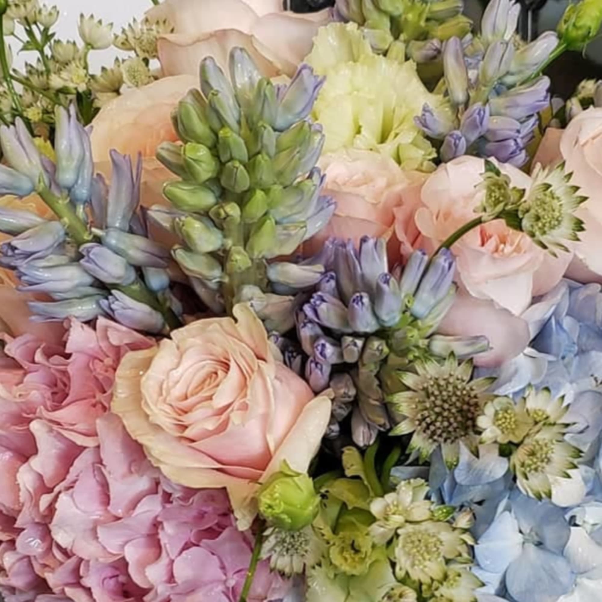 Pastel bouquet with roses, hydrangeas, and blue-purple flowers