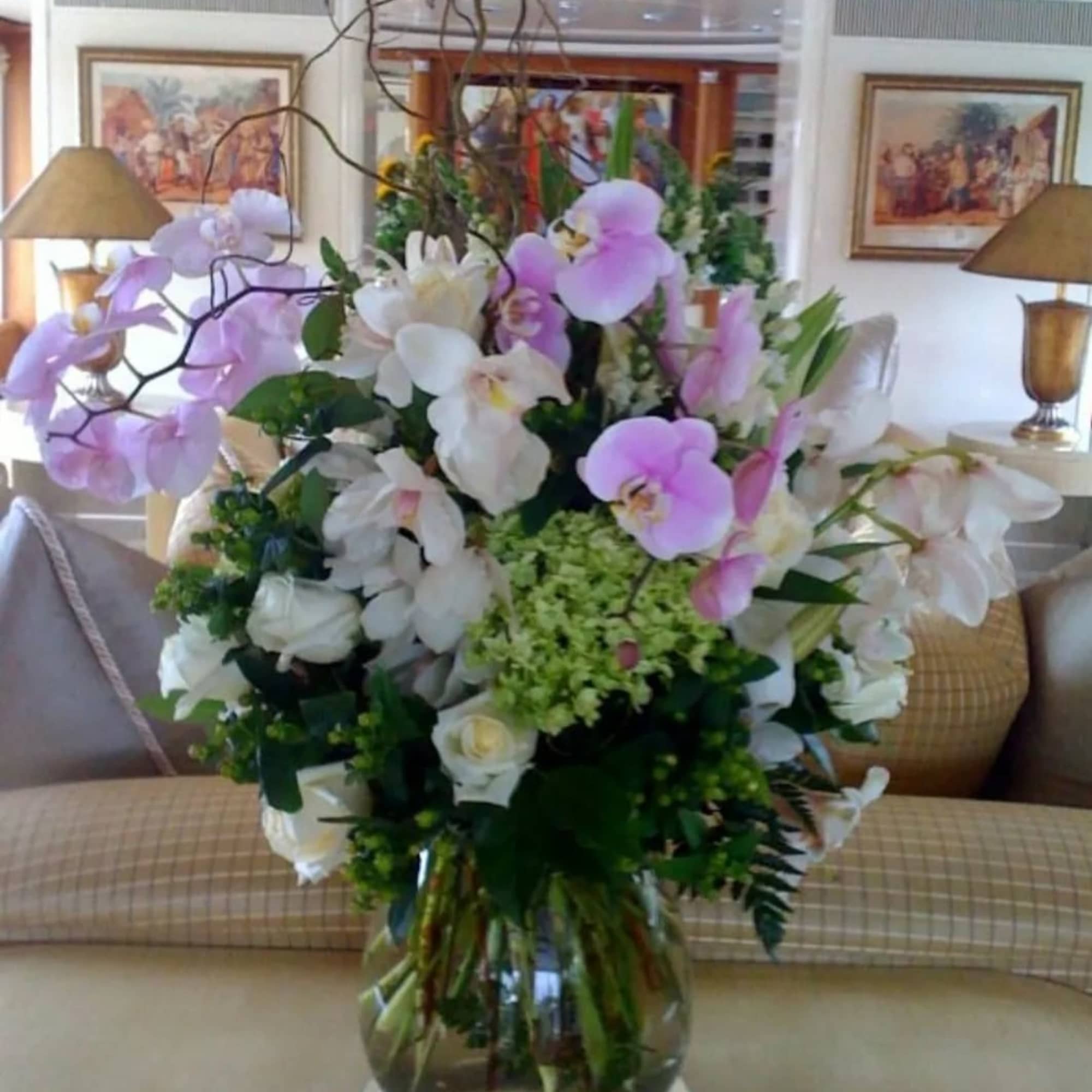 Large bouquet of pink and white orchids in a clear glass vase