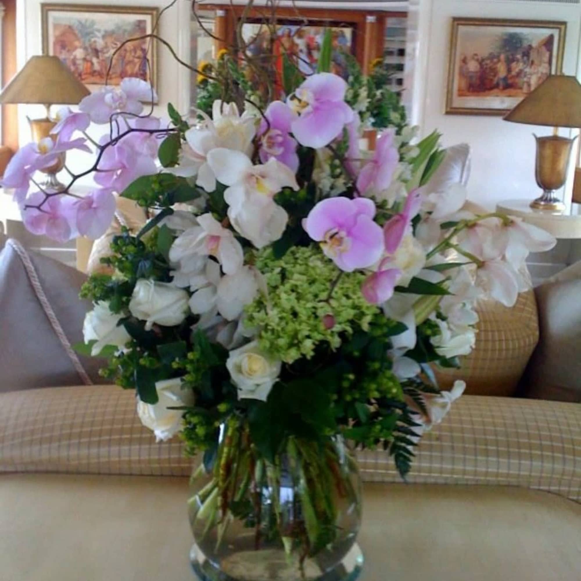 Large bouquet of white and pink orchids in a glass vase