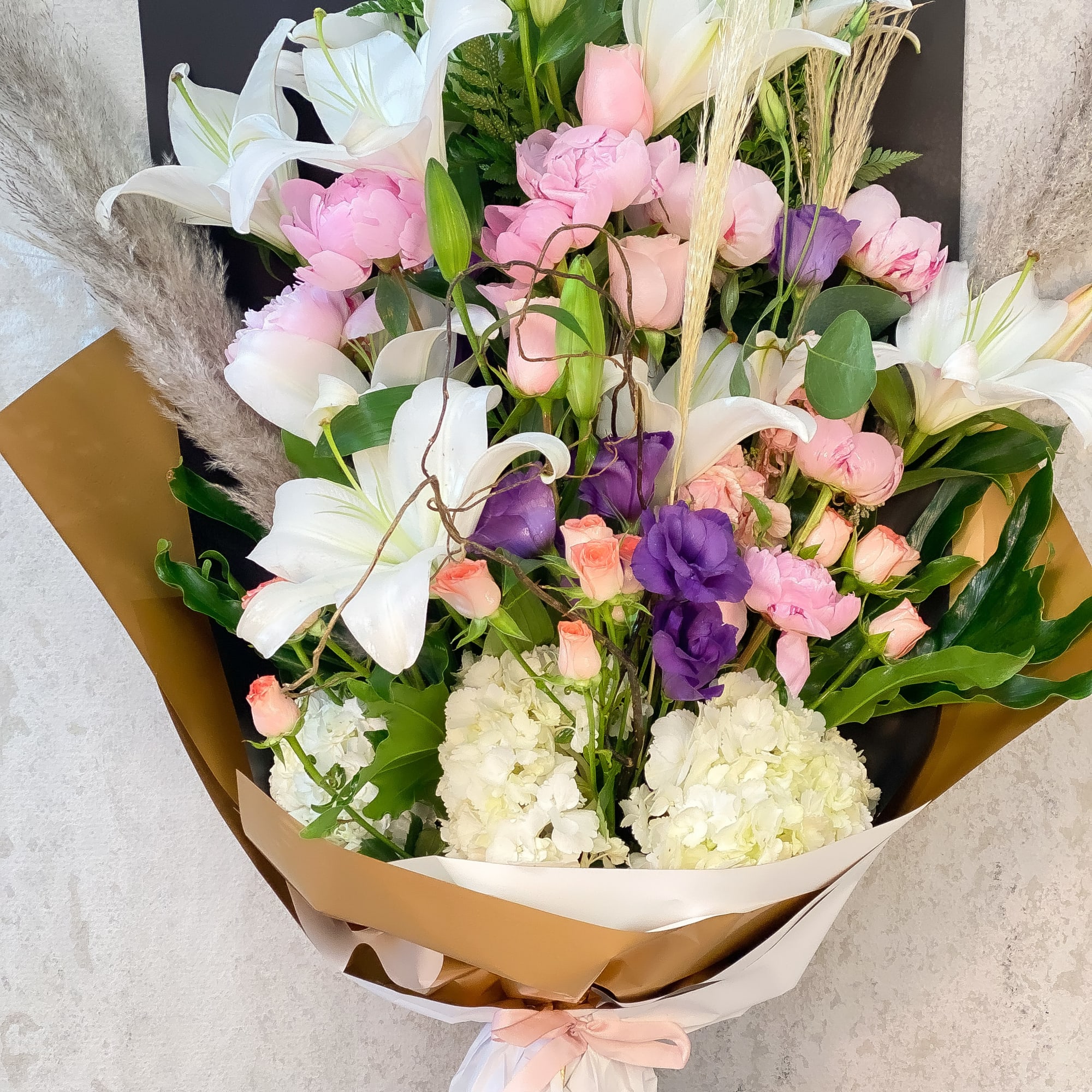 Large bouquet of white lilies, pink and purple flowers, and white hydrangeas