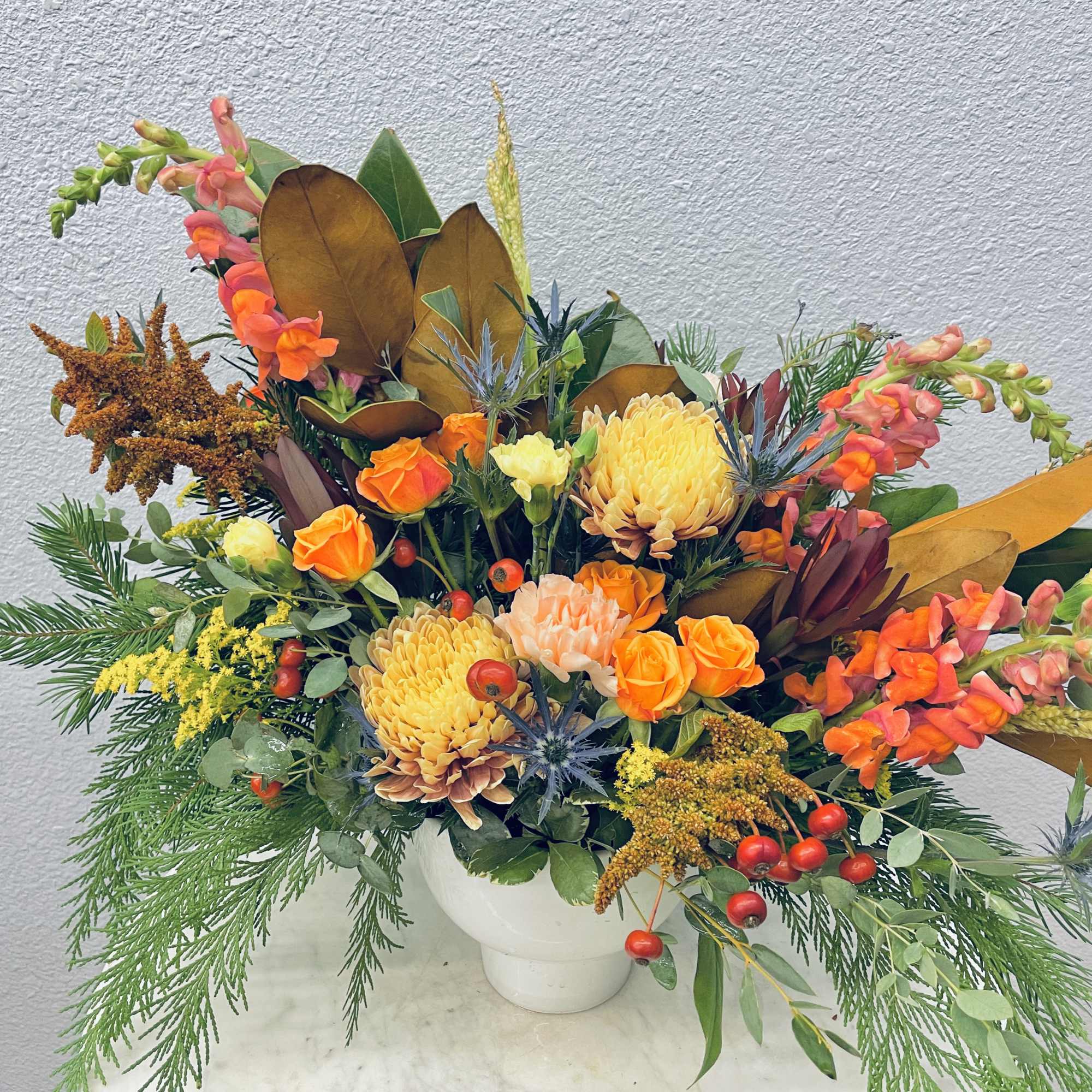 Seasonal flowers paired with seasonal greens in a neutral ceramic pot
*Photo shows, photo 2 of 3
