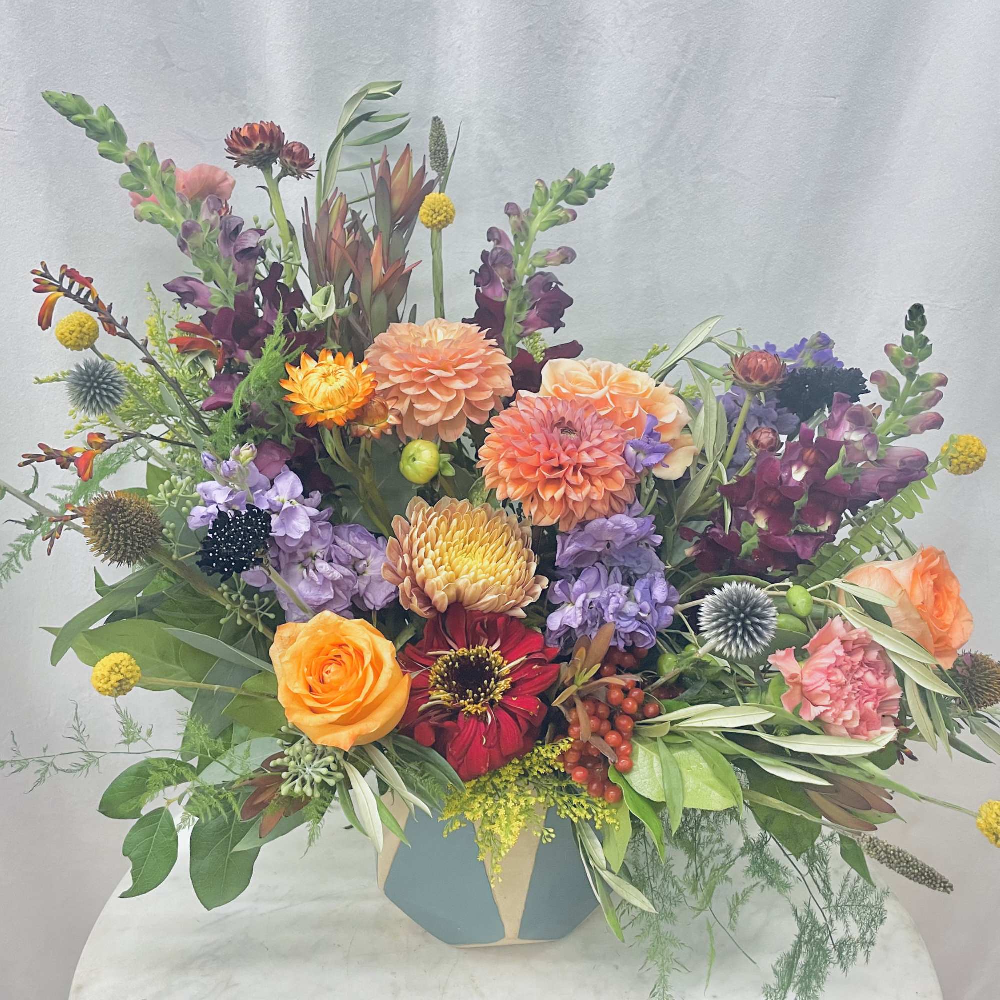 Colorful mixed flower arrangement in a geometric vase