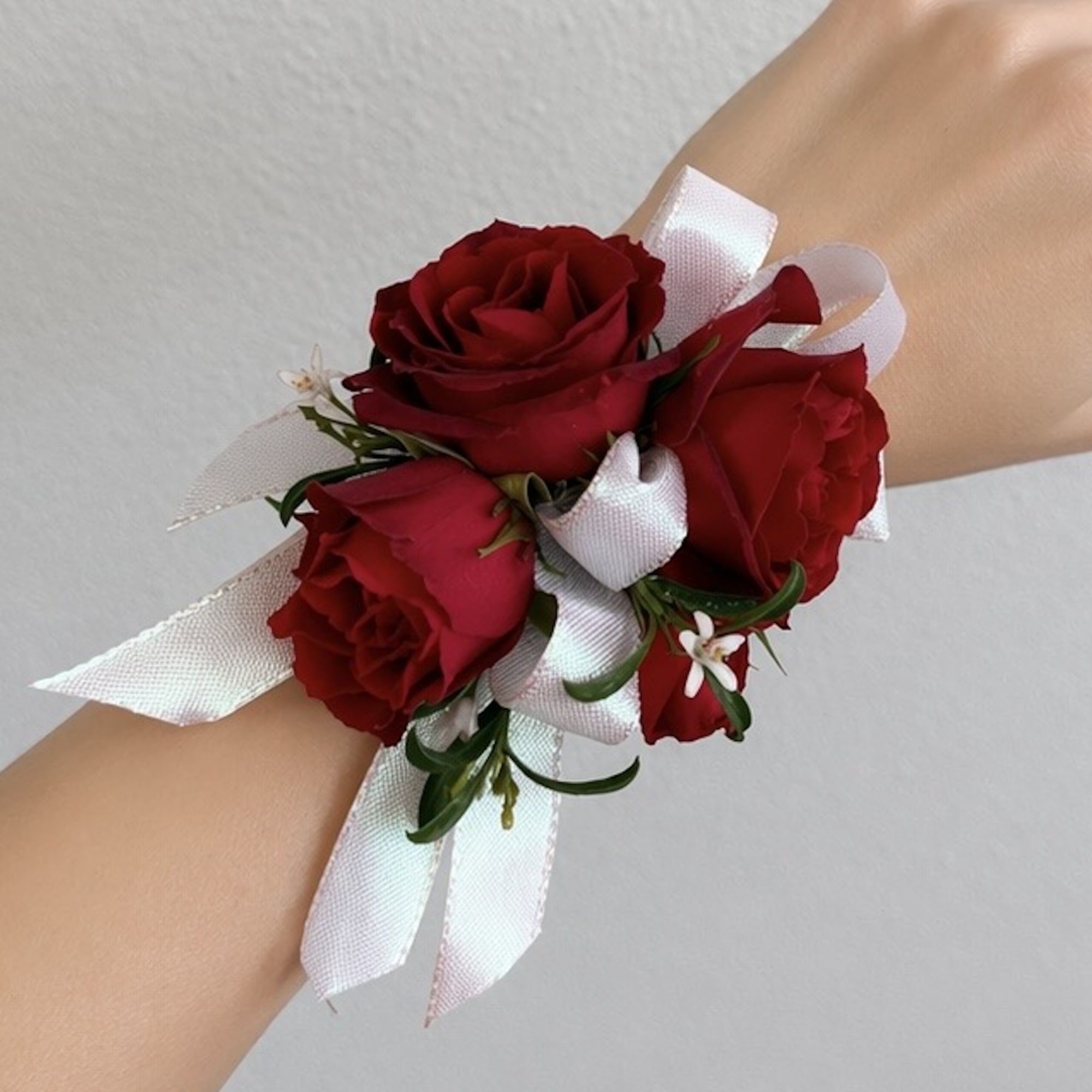 Red rose wrist corsage with white ribbon