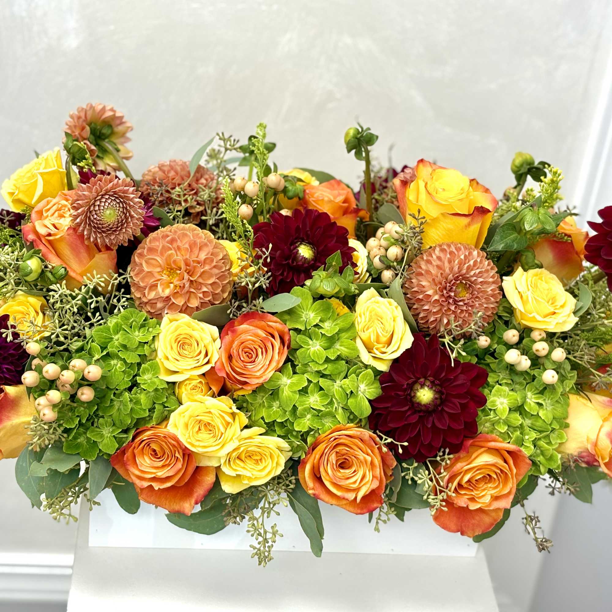 Mixed bouquet of orange, yellow, and burgundy flowers