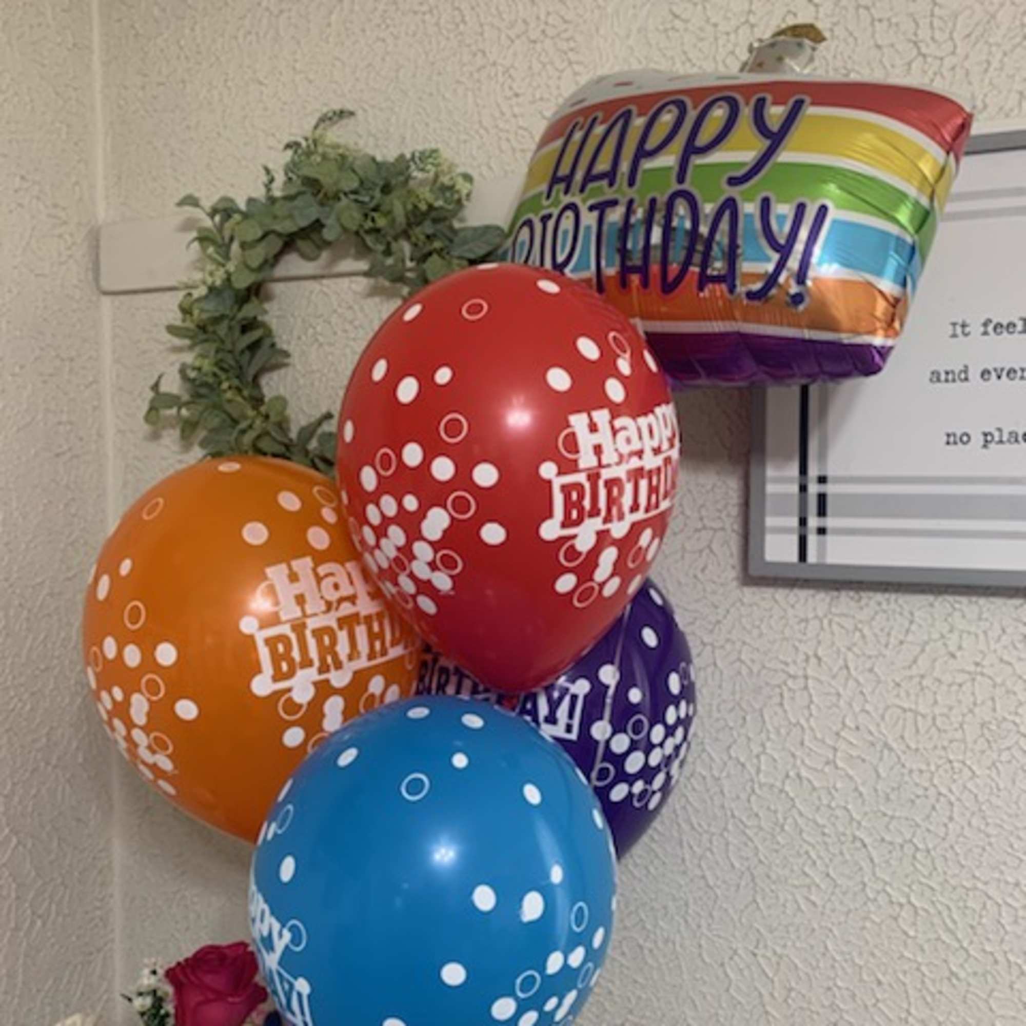 Birthday balloons above a small mixed flower bouquet