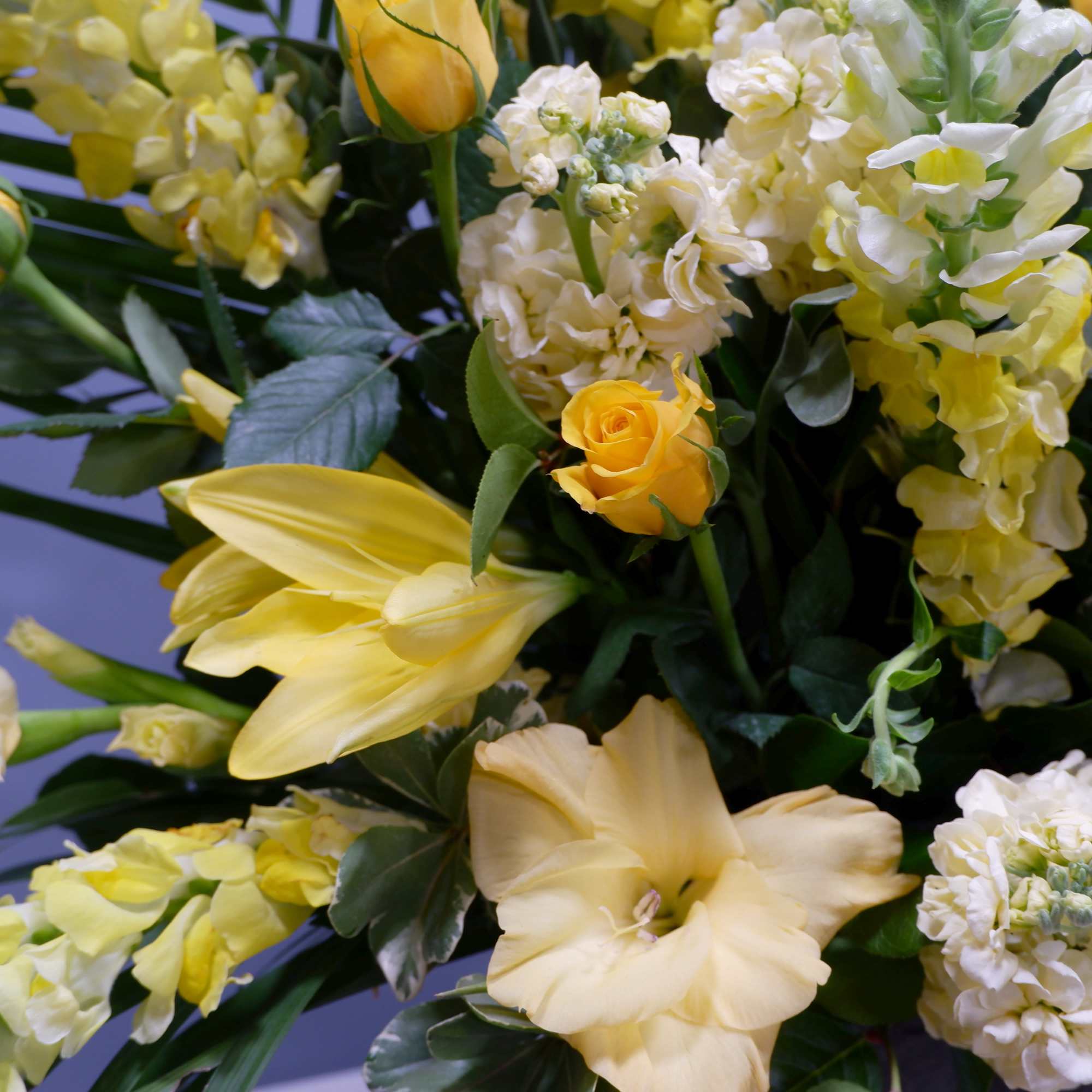Yellow and white floral arrangement with roses, lilies, and gerbera daisies