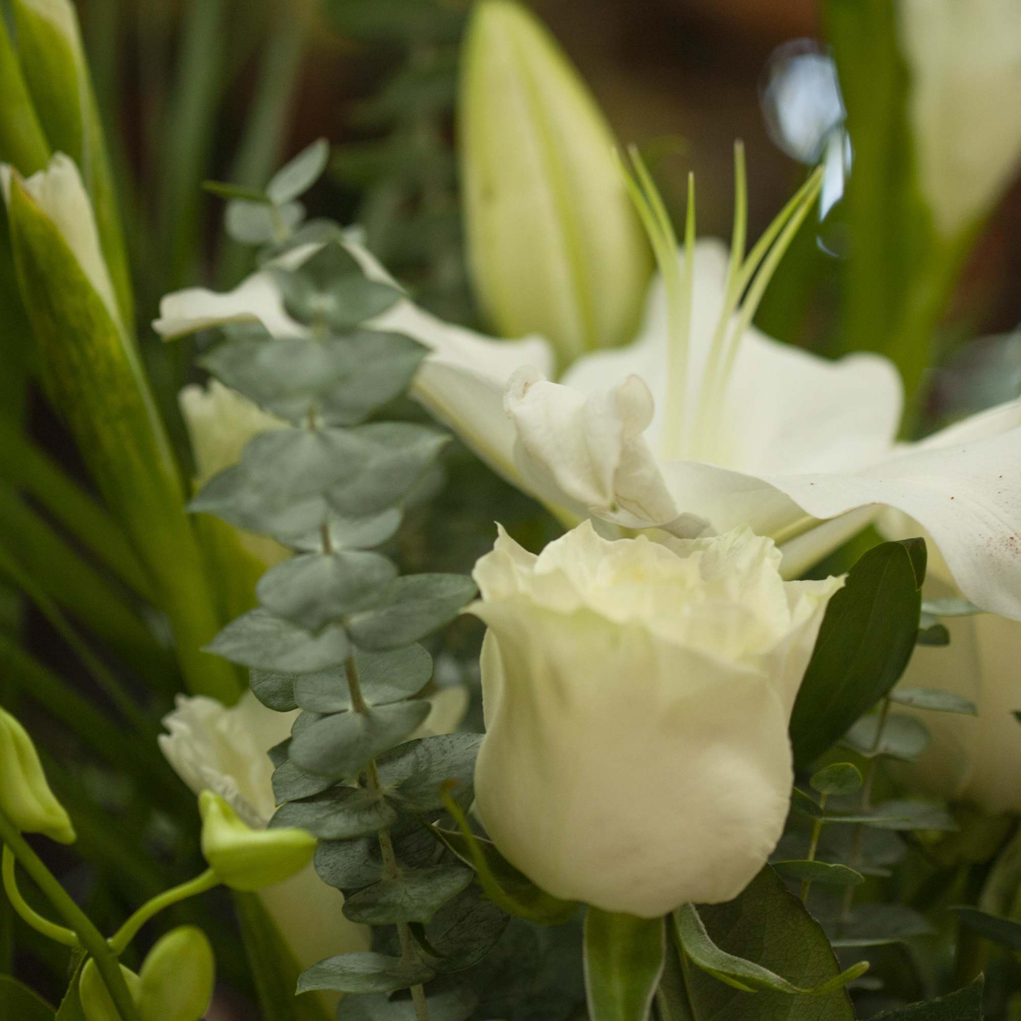 White lilies and roses arranged with greenery