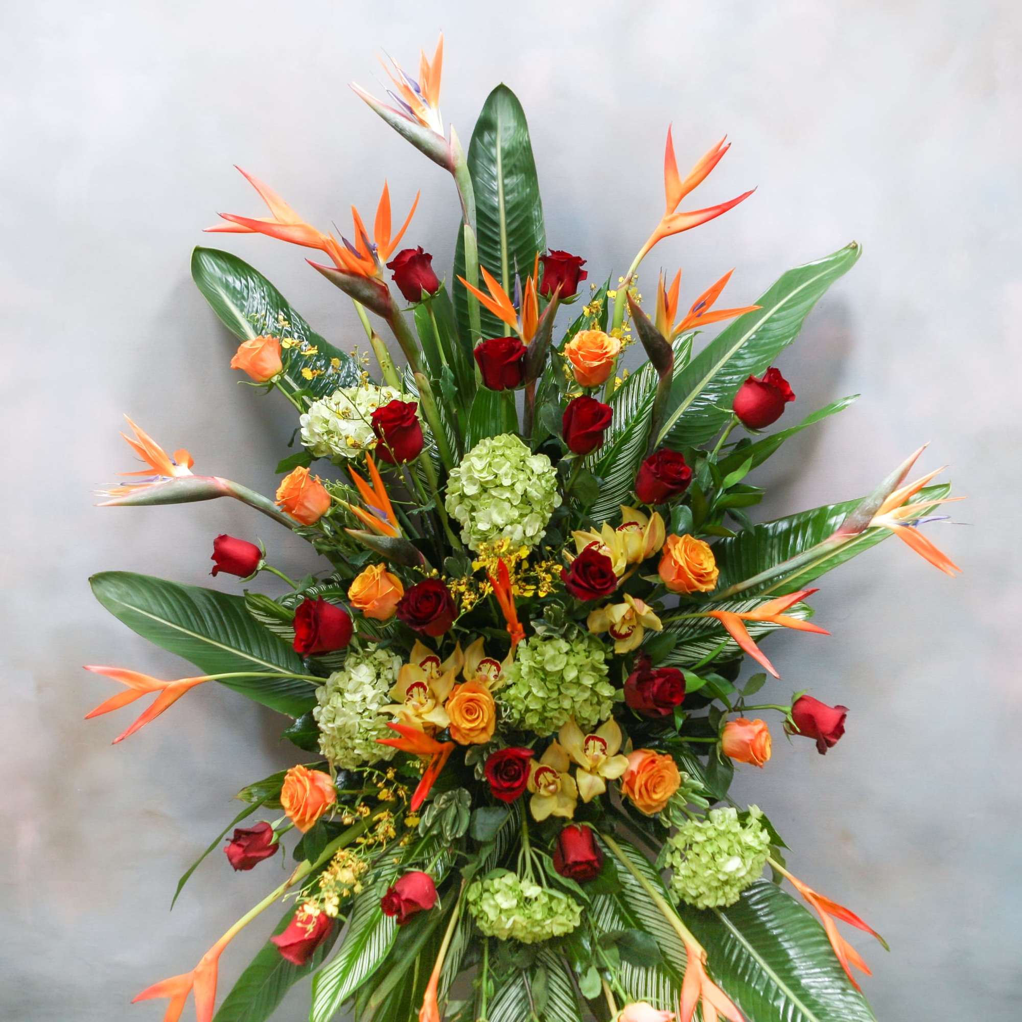 Tall tropical arrangement with roses, orchids, and bird-of-paradise flowers