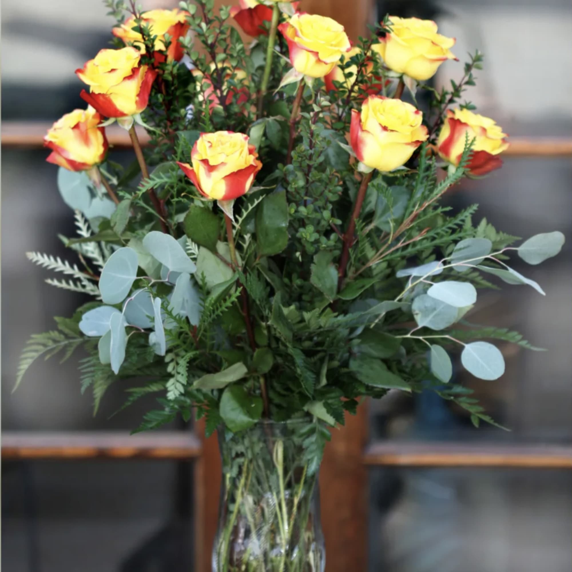 Yellow and red roses in a clear glass vase