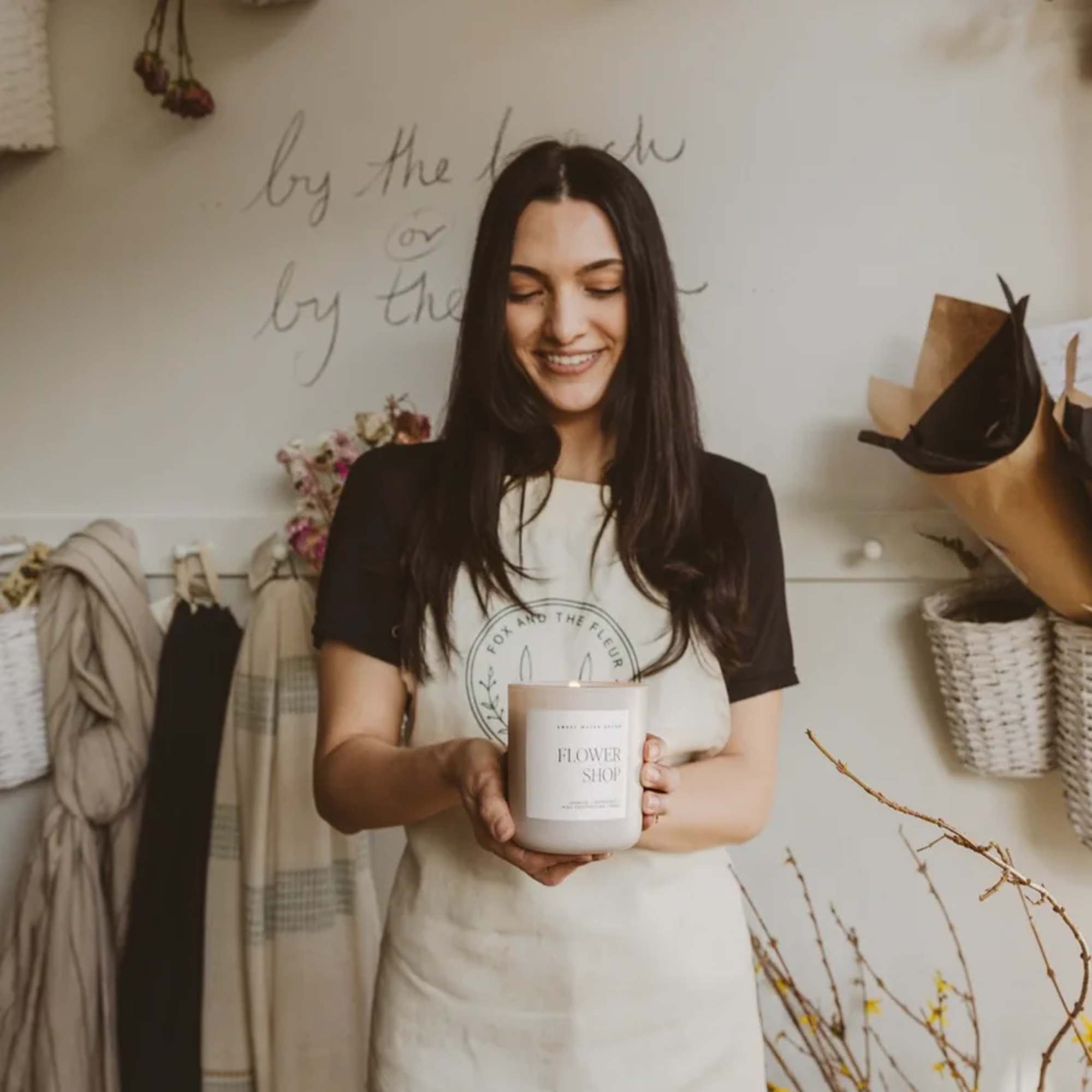 Woman holding a flower shop candle in a studio setting