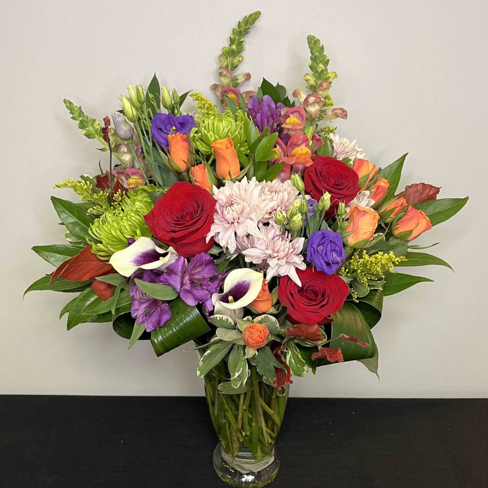 Vase arrangement of assorted flowers in rich fall colours, perfect for the