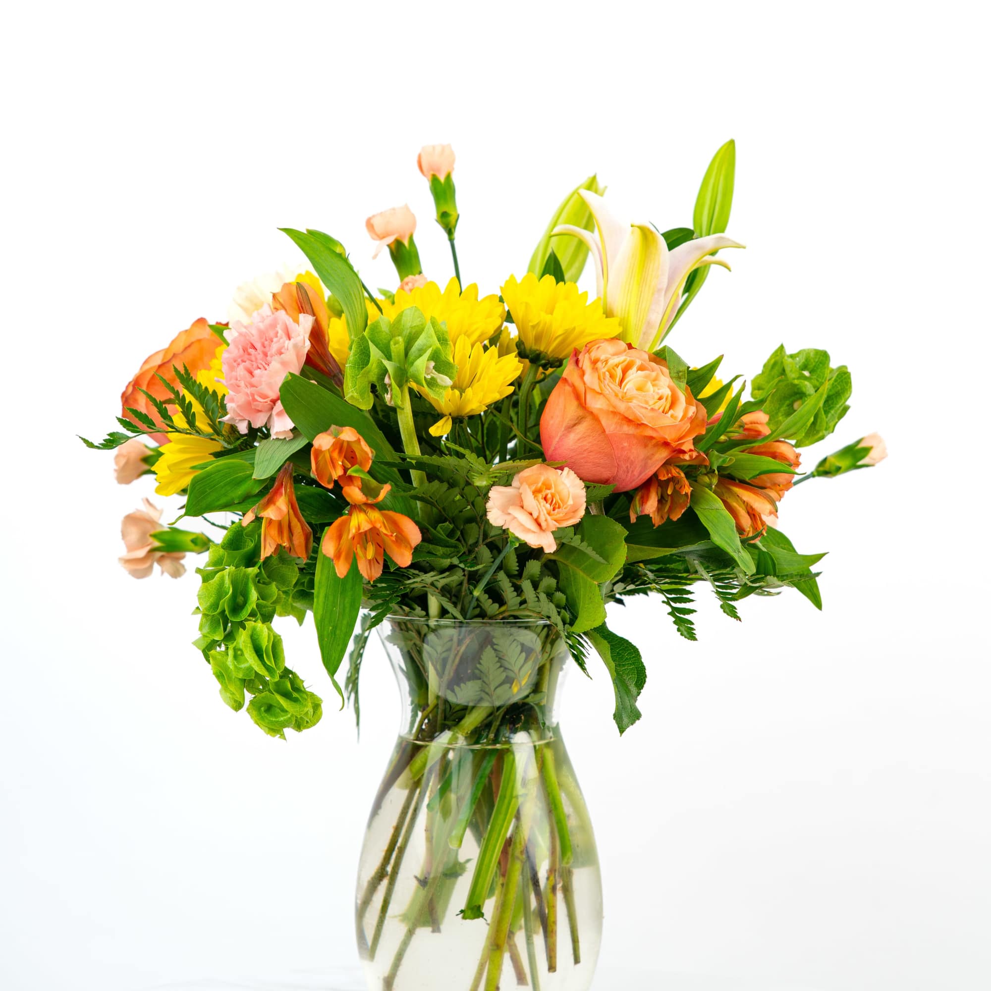 Bright mixed bouquet of orange, yellow, and pink flowers in a clear glass vase