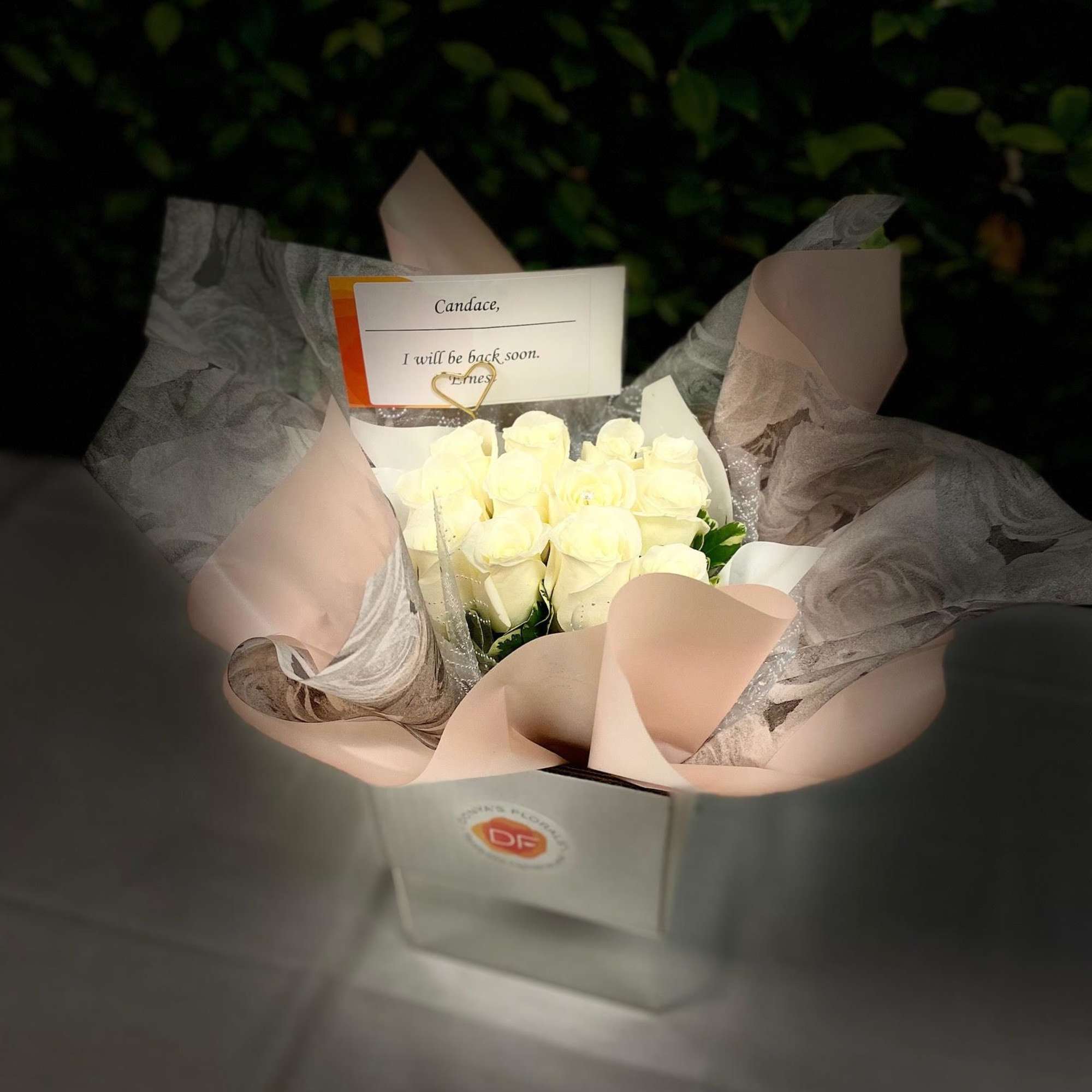 Bouquet of white roses wrapped in pale pink paper