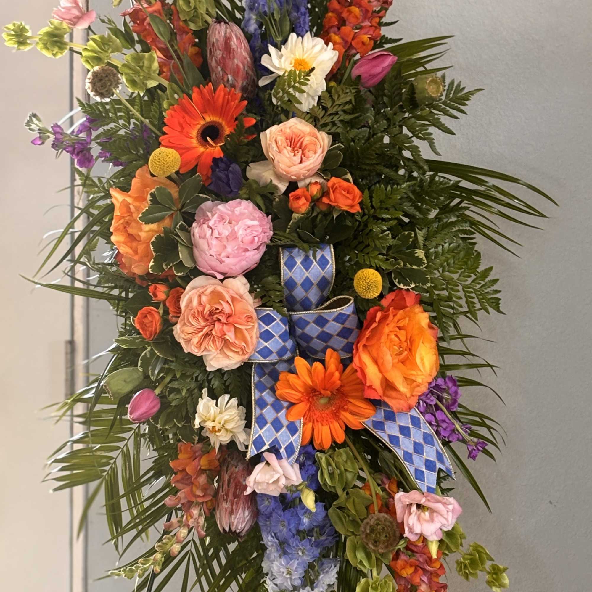 A bold, tall standing floral spray that reads like a joyous, ceremonial