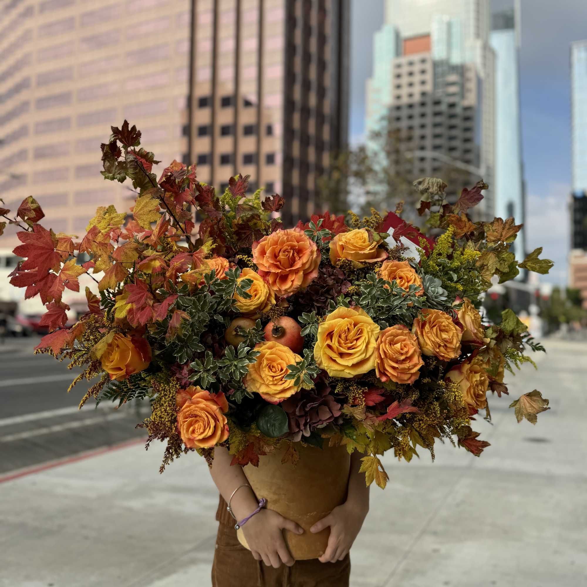 Large bouquet of orange and yellow roses in a brown vase