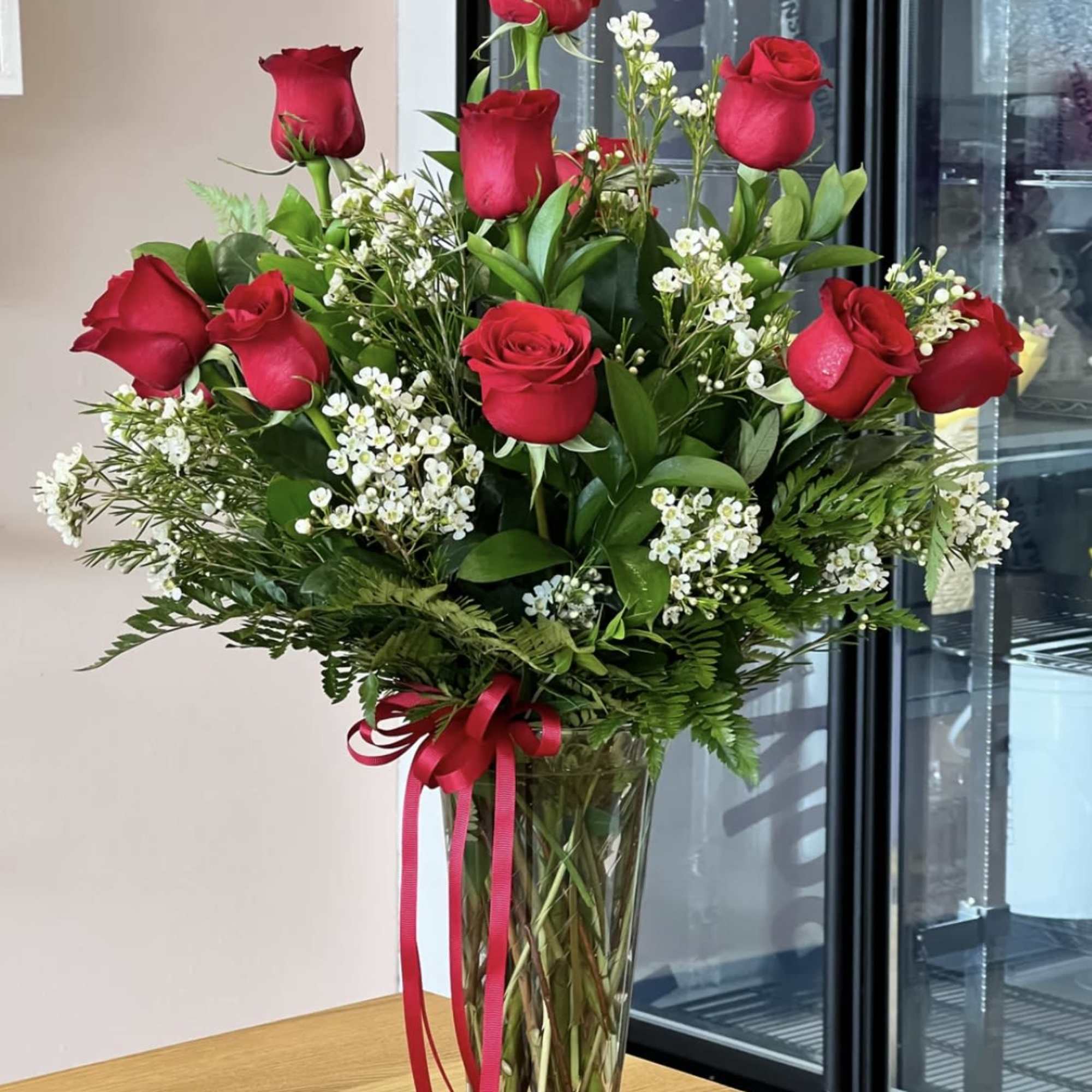 1 dozen red roses with greens and filler flowers (filler will depend