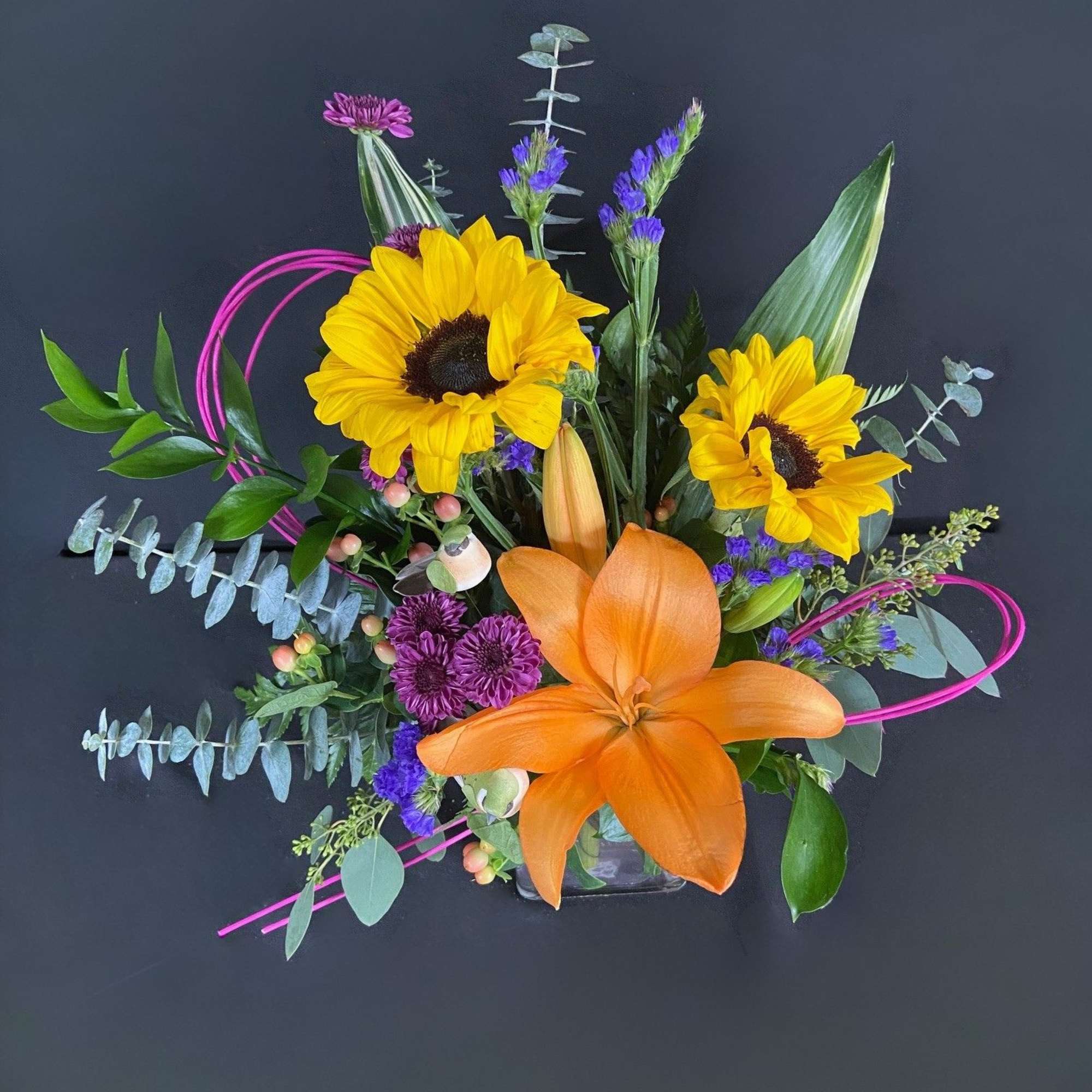 Bouquet with sunflowers and an orange lily in a low vase