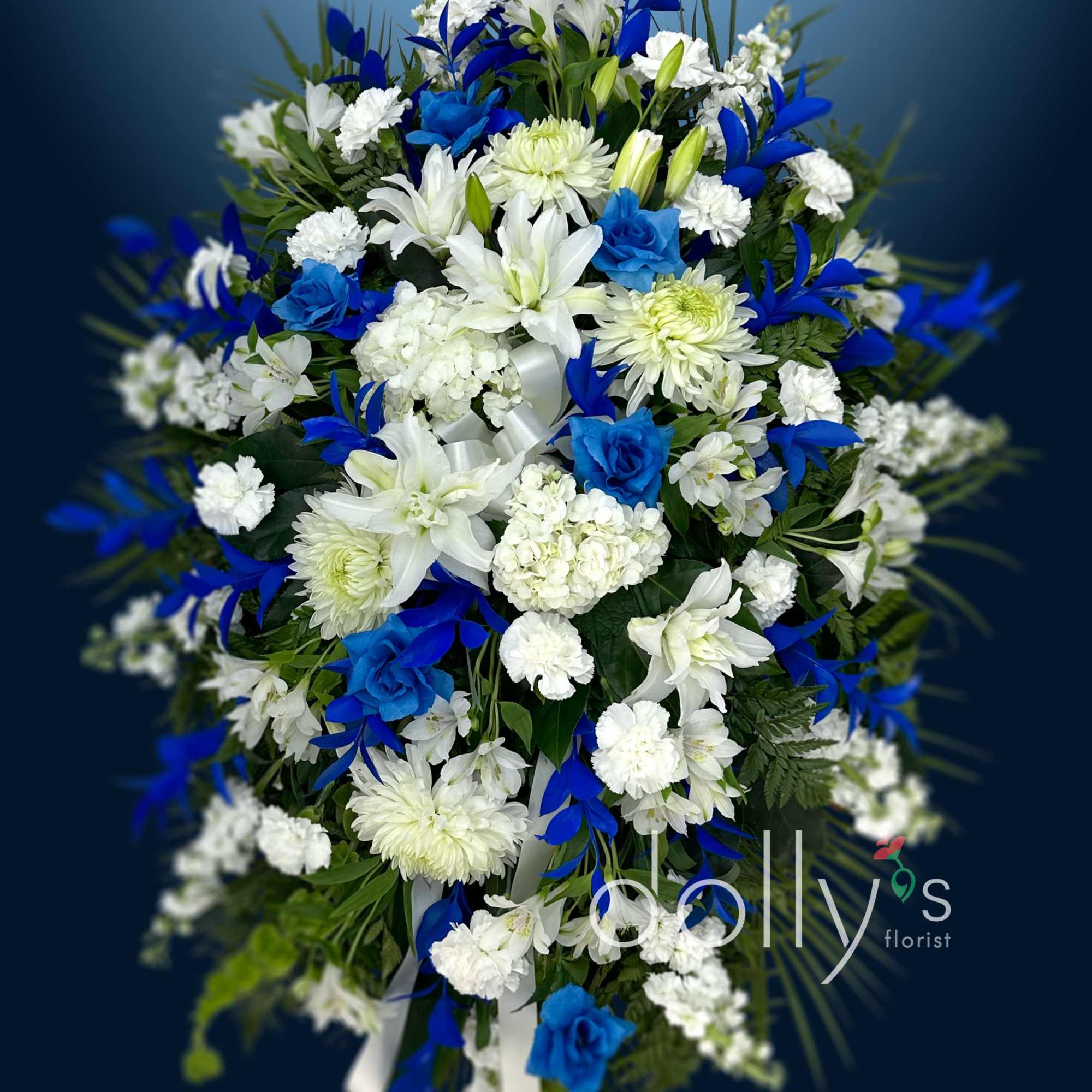 Blue and white funeral spray with lilies and chrysanthemums